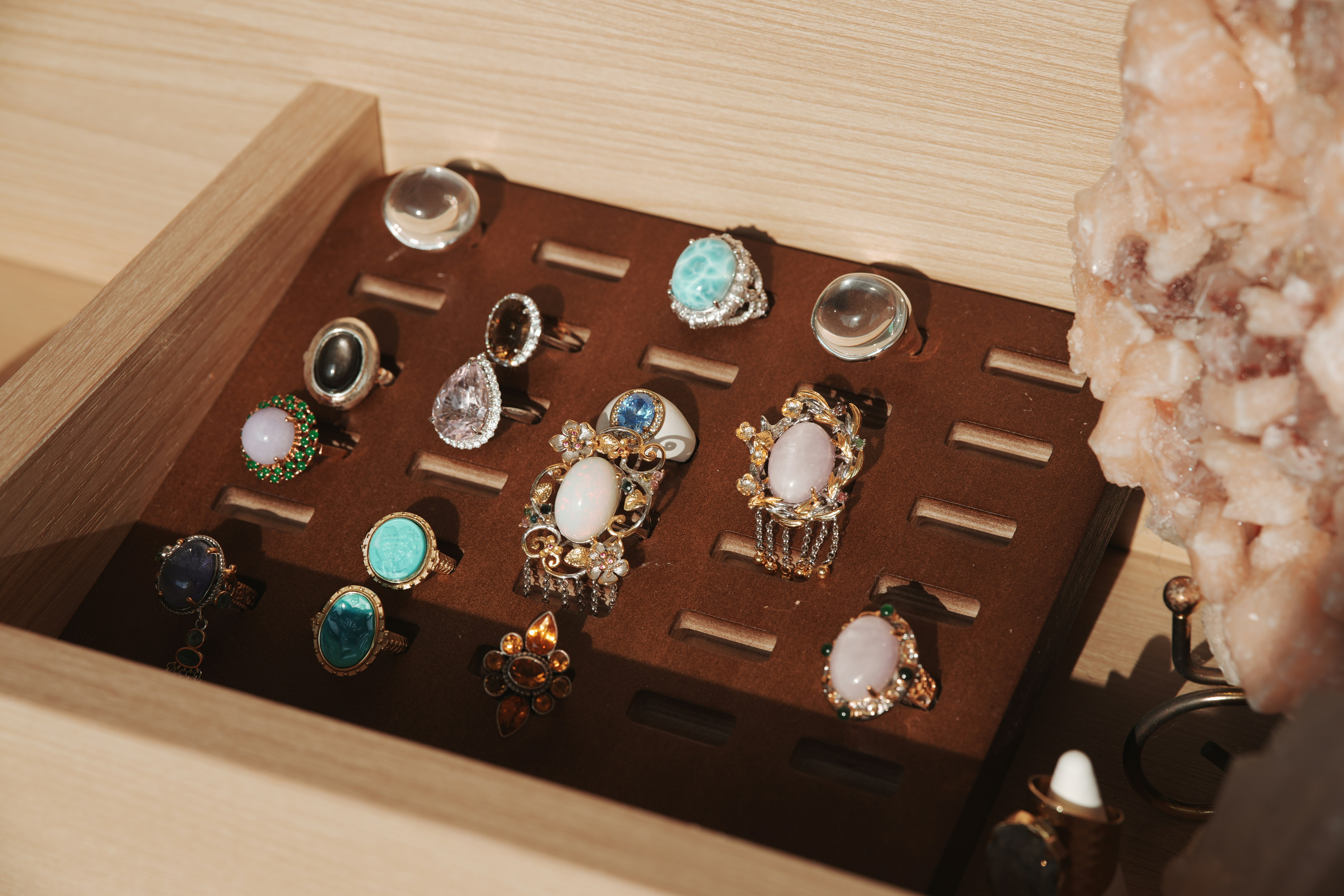 Assortment of decorative rings displayed on a wooden stand.