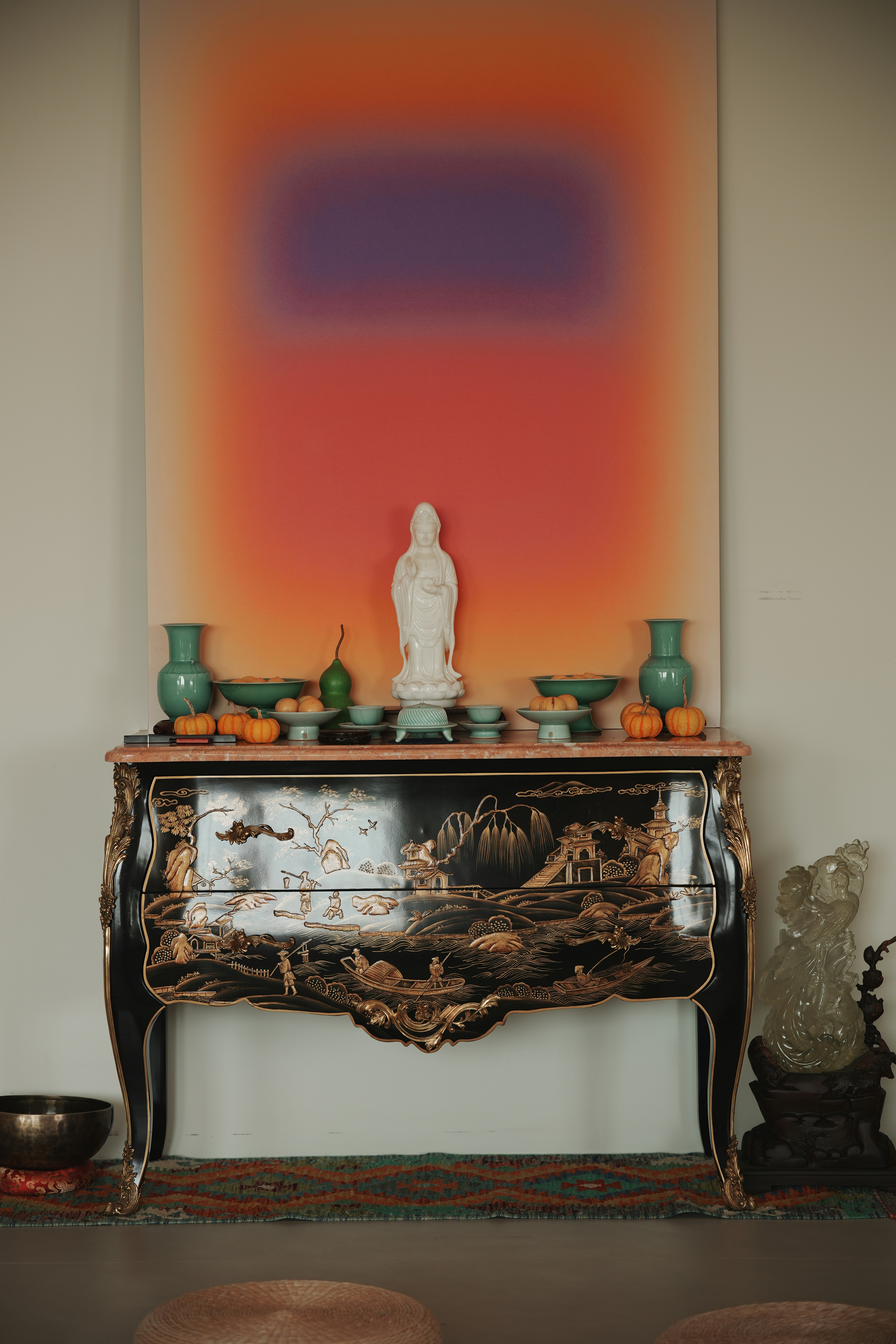 Ornate cabinet with buddhist statue and vibrant abstract art