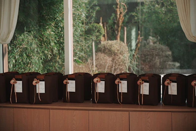 Brown bags with tags lined up on a shelf.