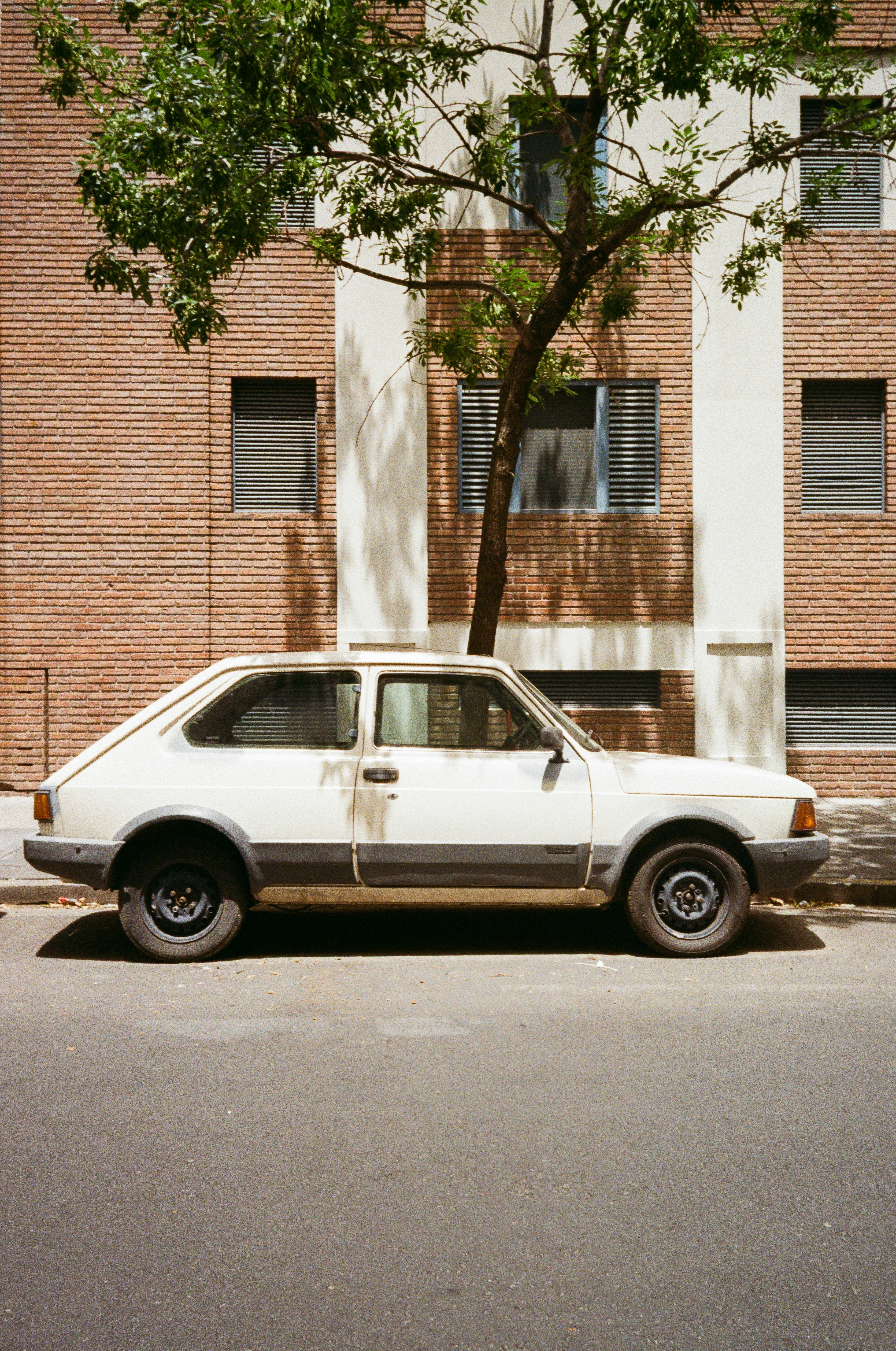 A white vintage car parked on a street.