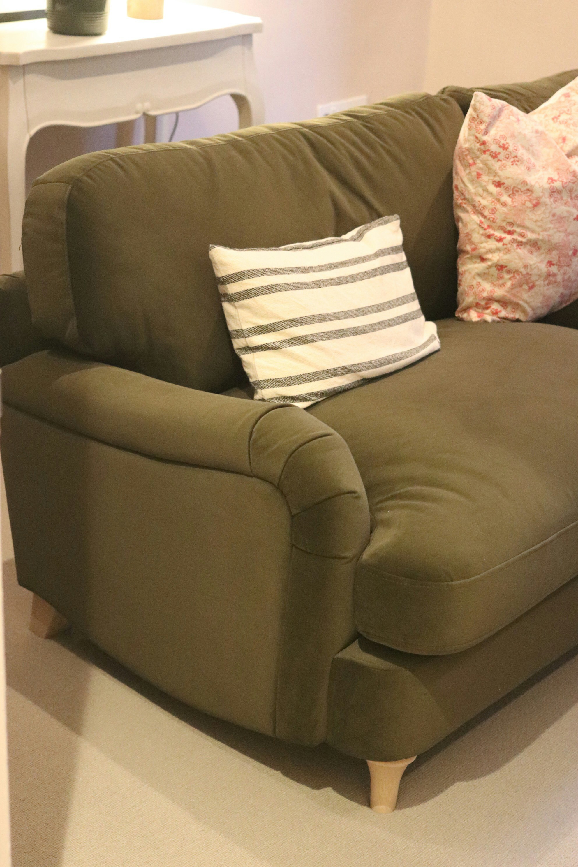 装飾用のクッションがついた快適な緑色のソファ