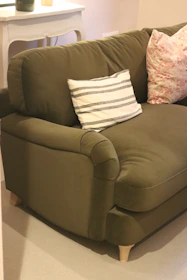 A comfortable green sofa with decorative pillows