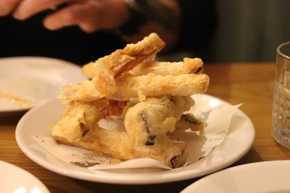 Fried food stacked on a white plate