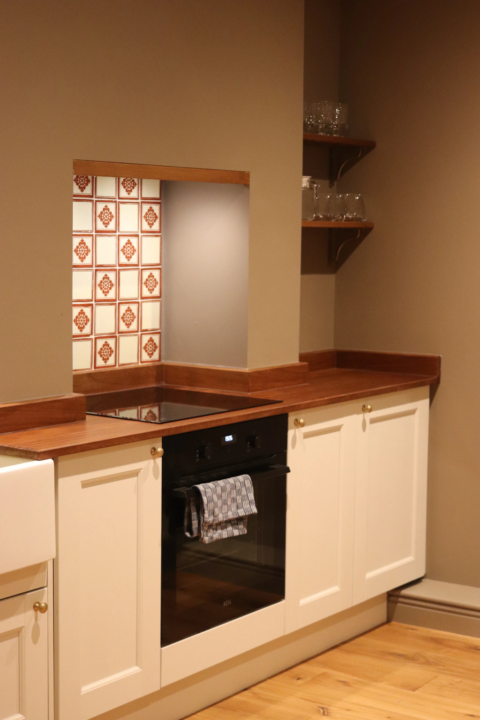 Kitchen with white cabinets, wood countertops, and clean everyday prep layout