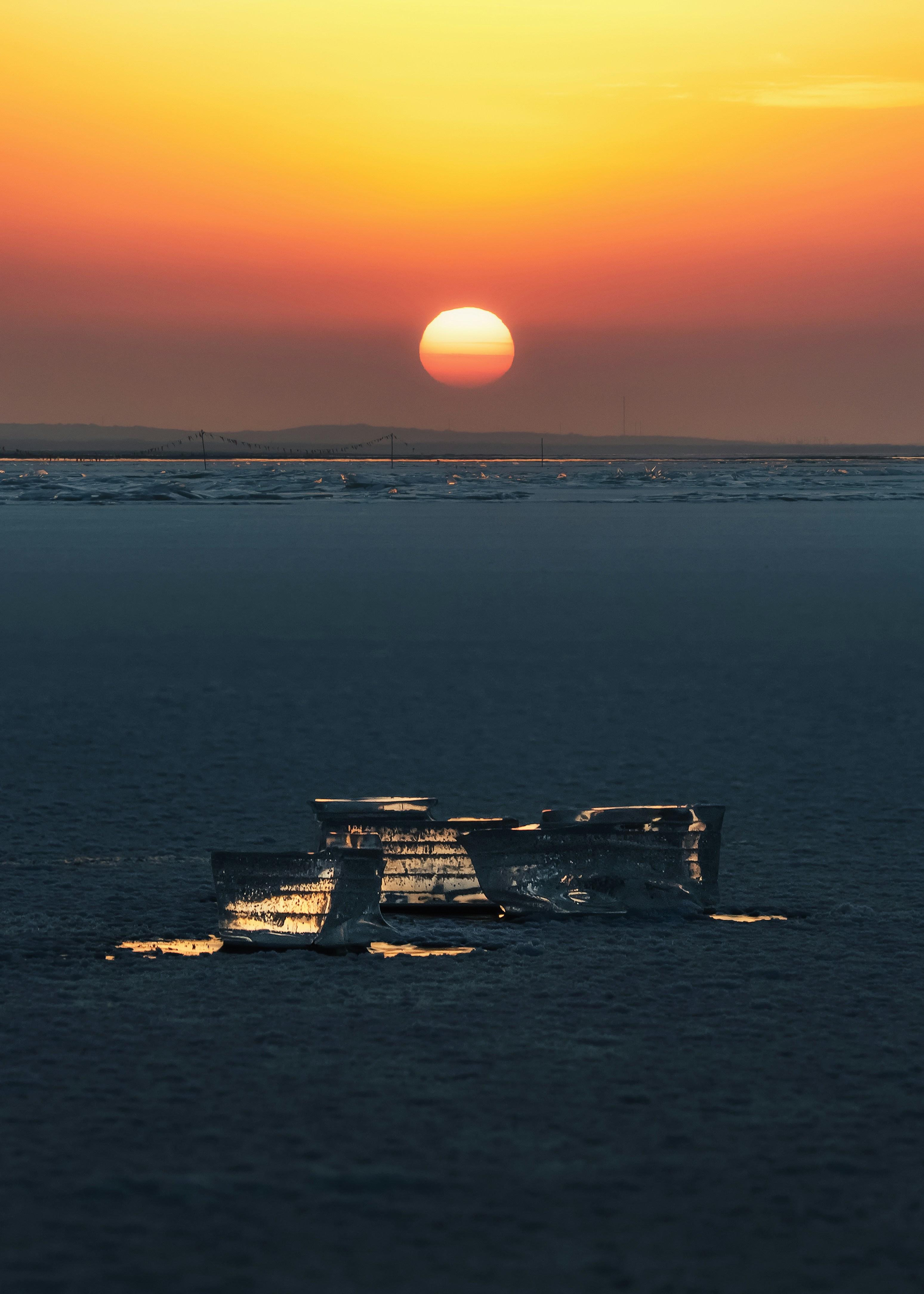 凍った風景に沈む夕日が氷の形成に包まれている。