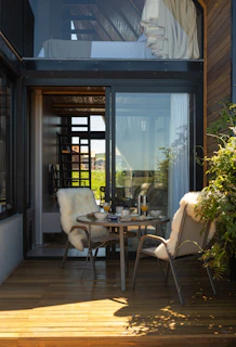 Cozy outdoor seating area with breakfast table and lush greenery.