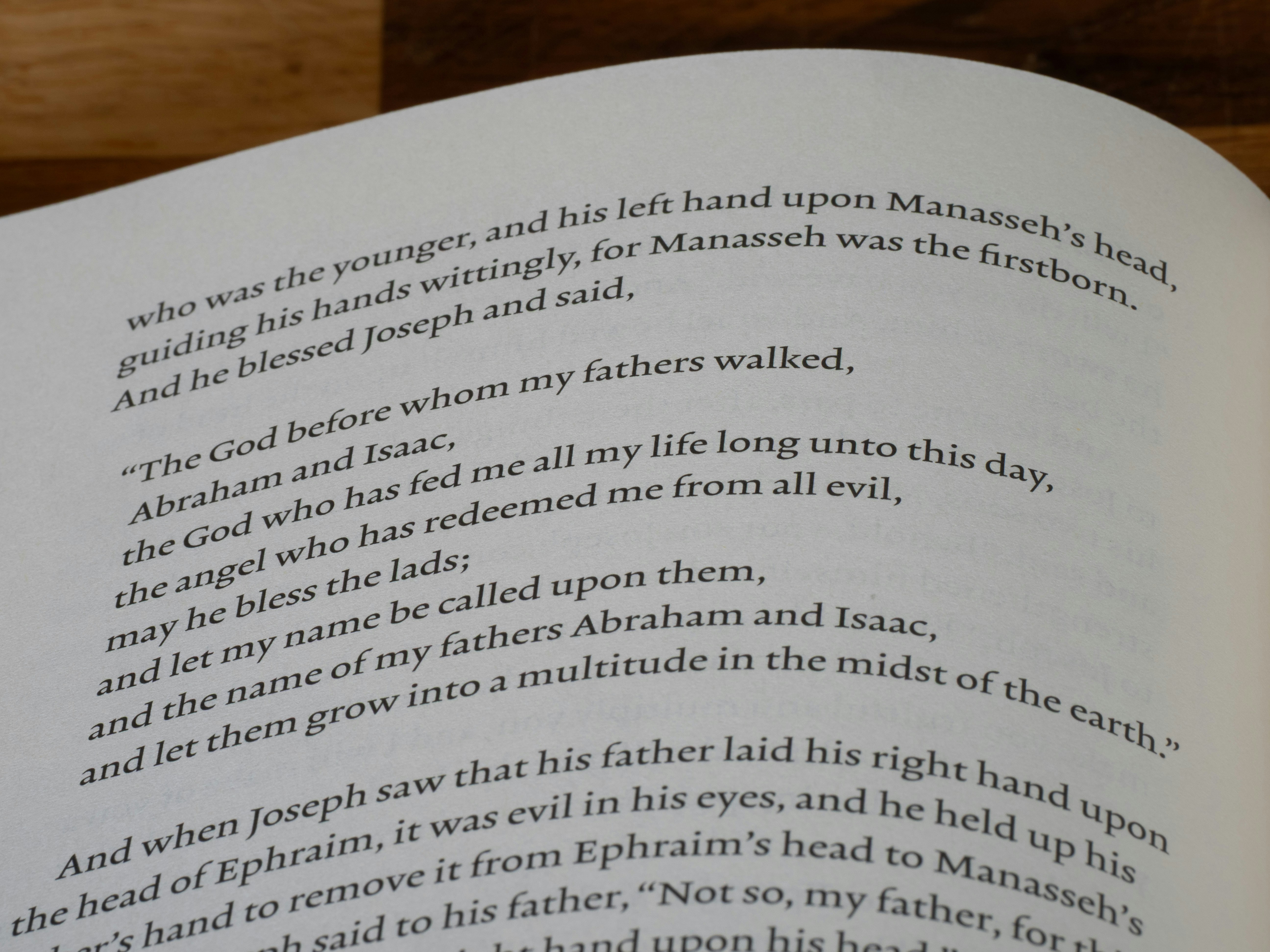 Close-up of text from a book on a wooden surface.