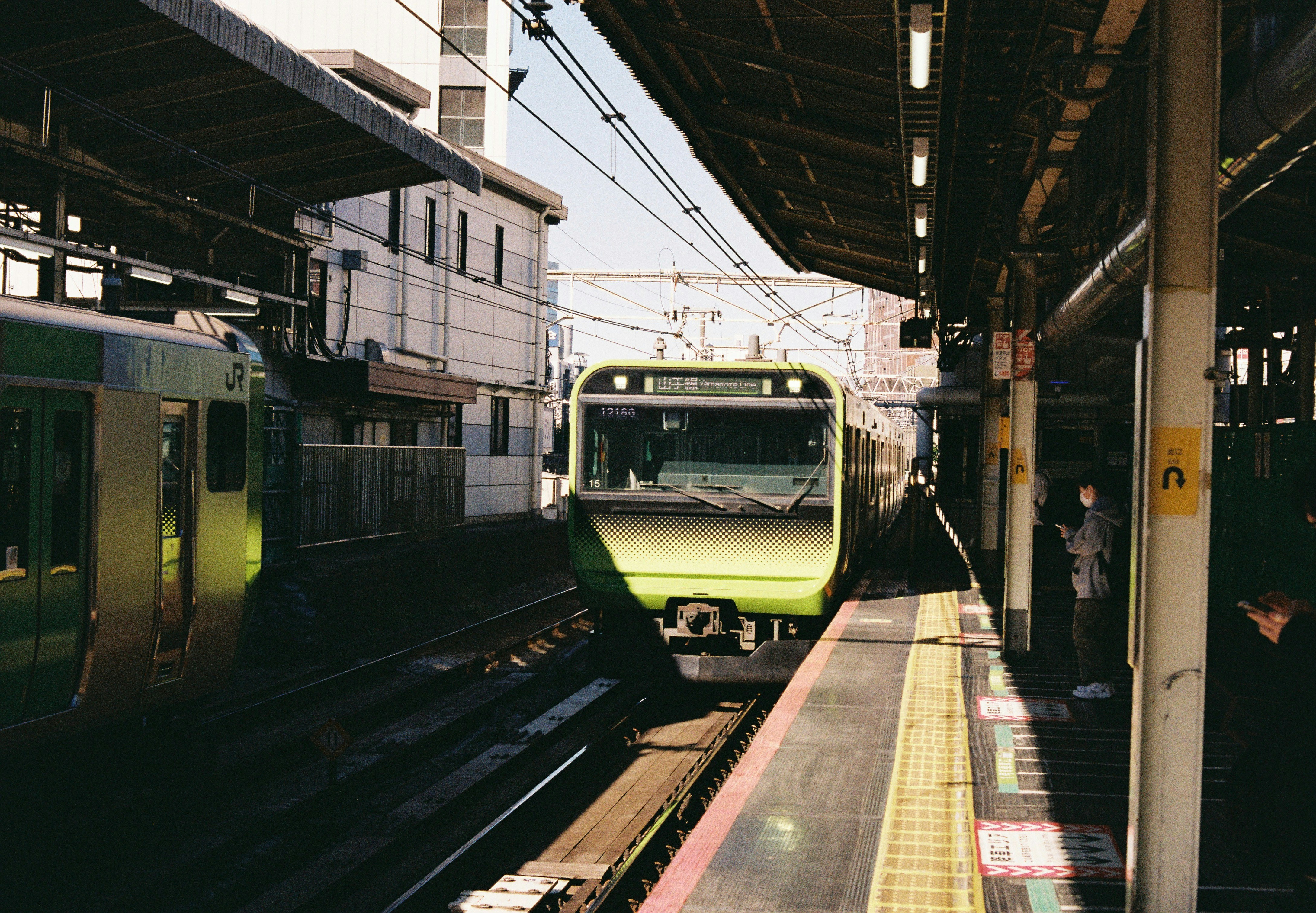 Two trains at a station platform under a roof.