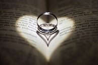 Wedding rings casting a heart shadow on a book