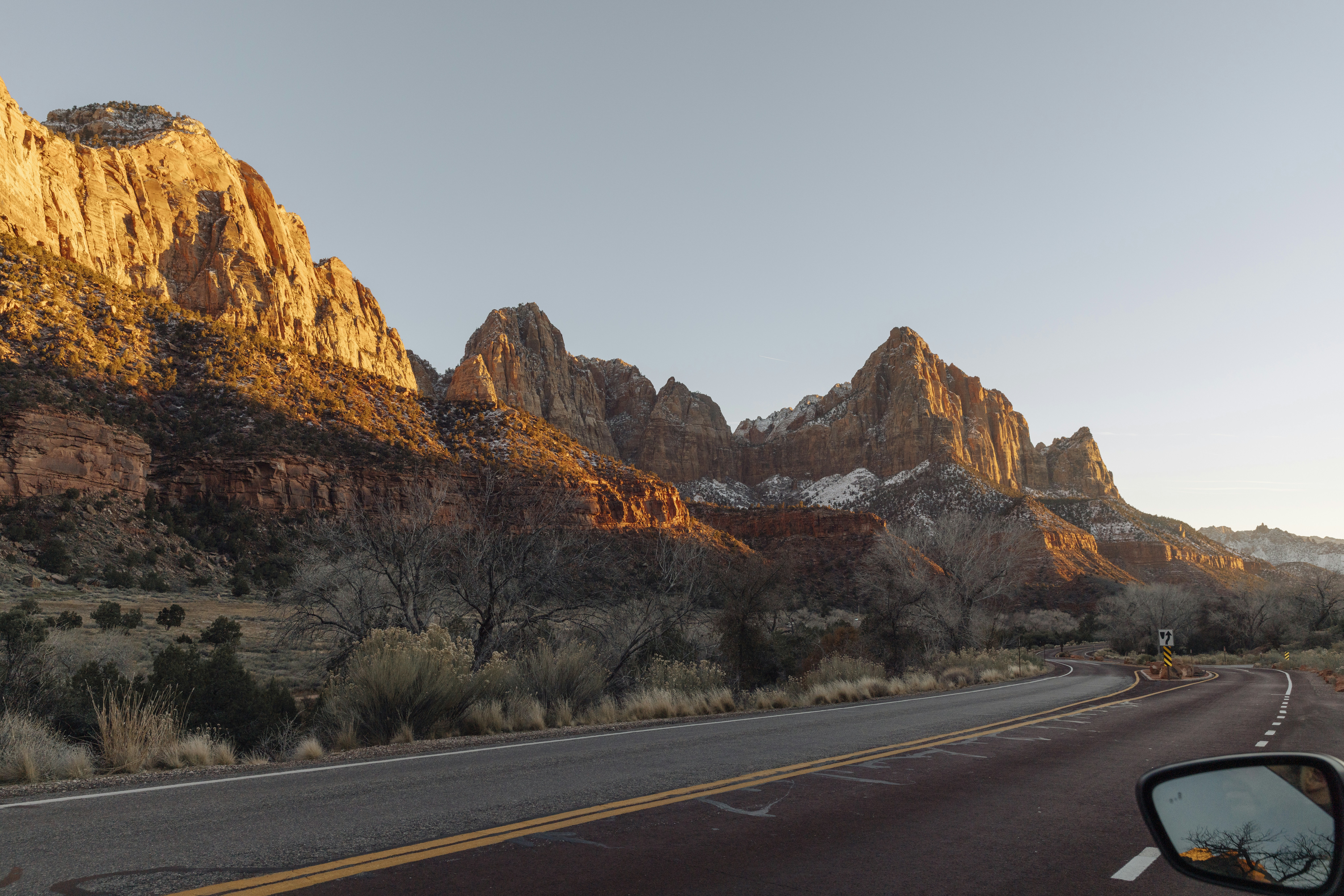 Route menant aux falaises de grès baignées de soleil au lever du soleil.