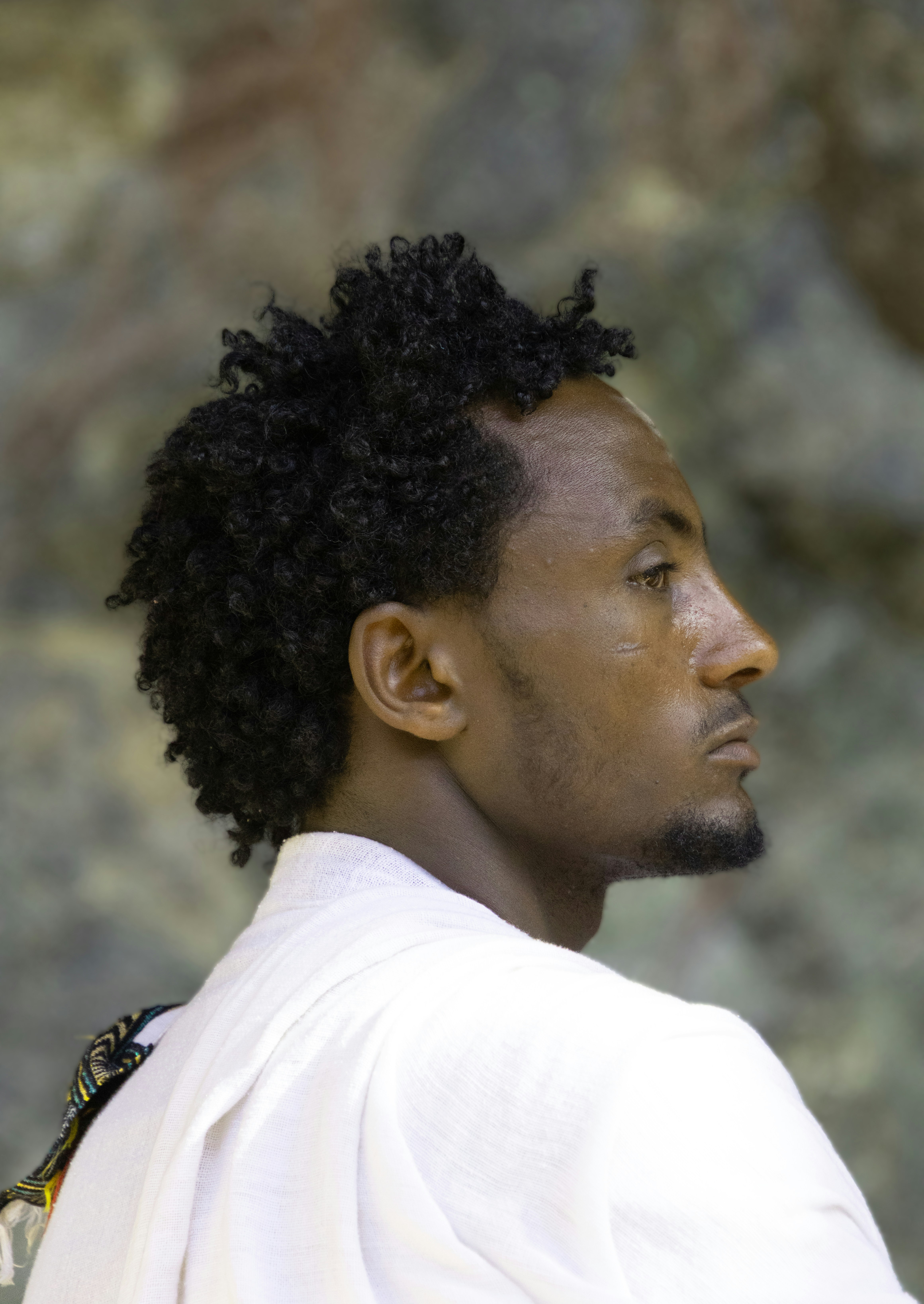 Man with curly hair in profile view.