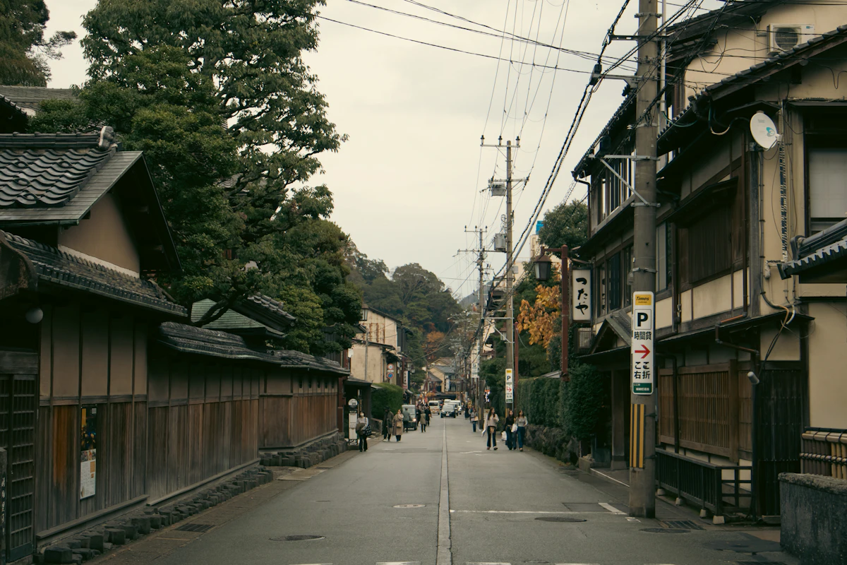A quiet street of traditional houses in Kinosaki Onsen with autumn foliage