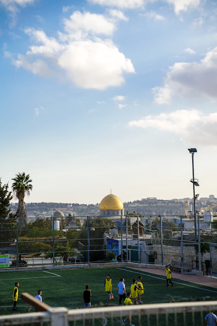 Children playing soccer with golden dome in background