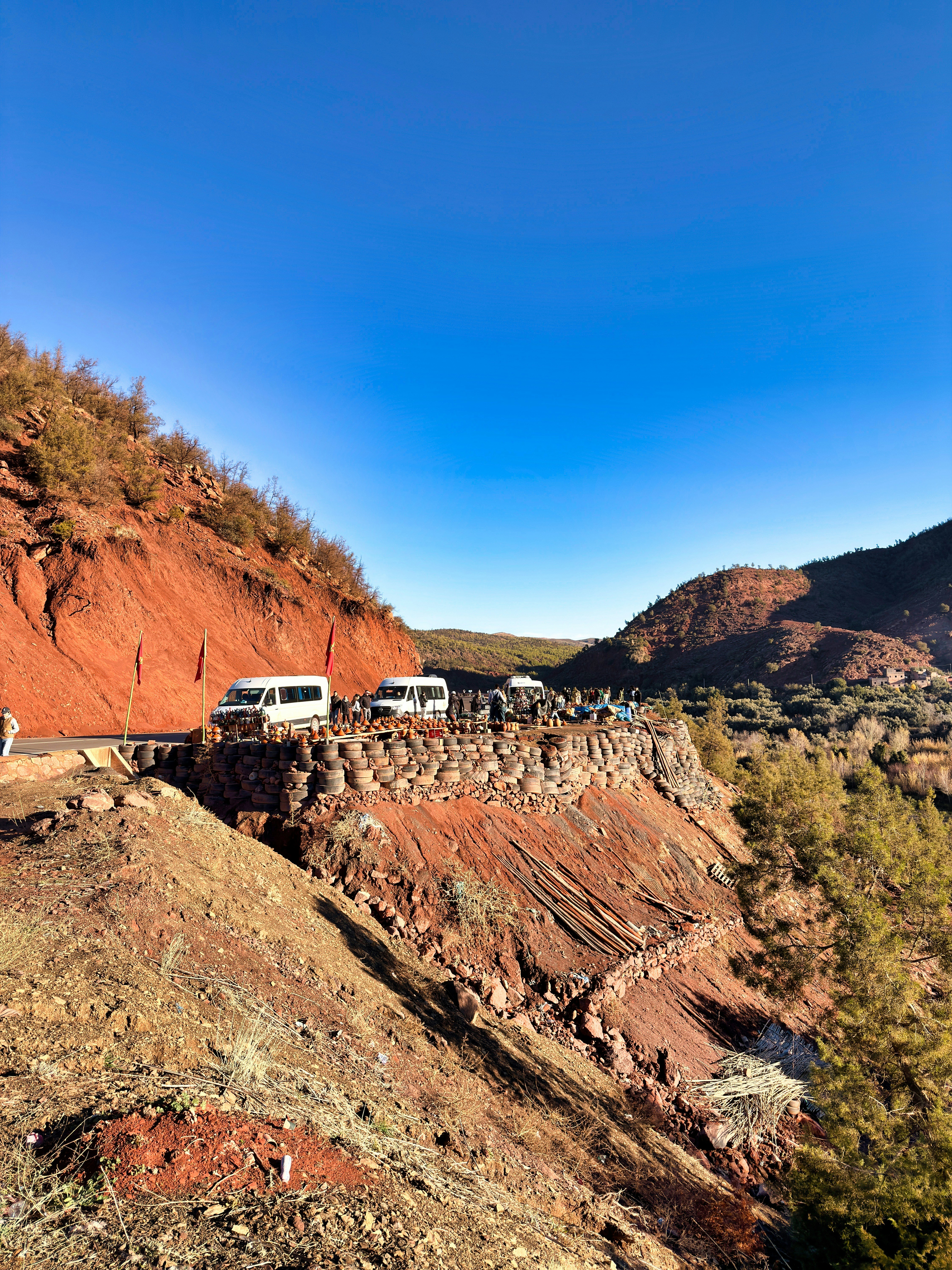 White vans parked on a scenic mountain road overlook.