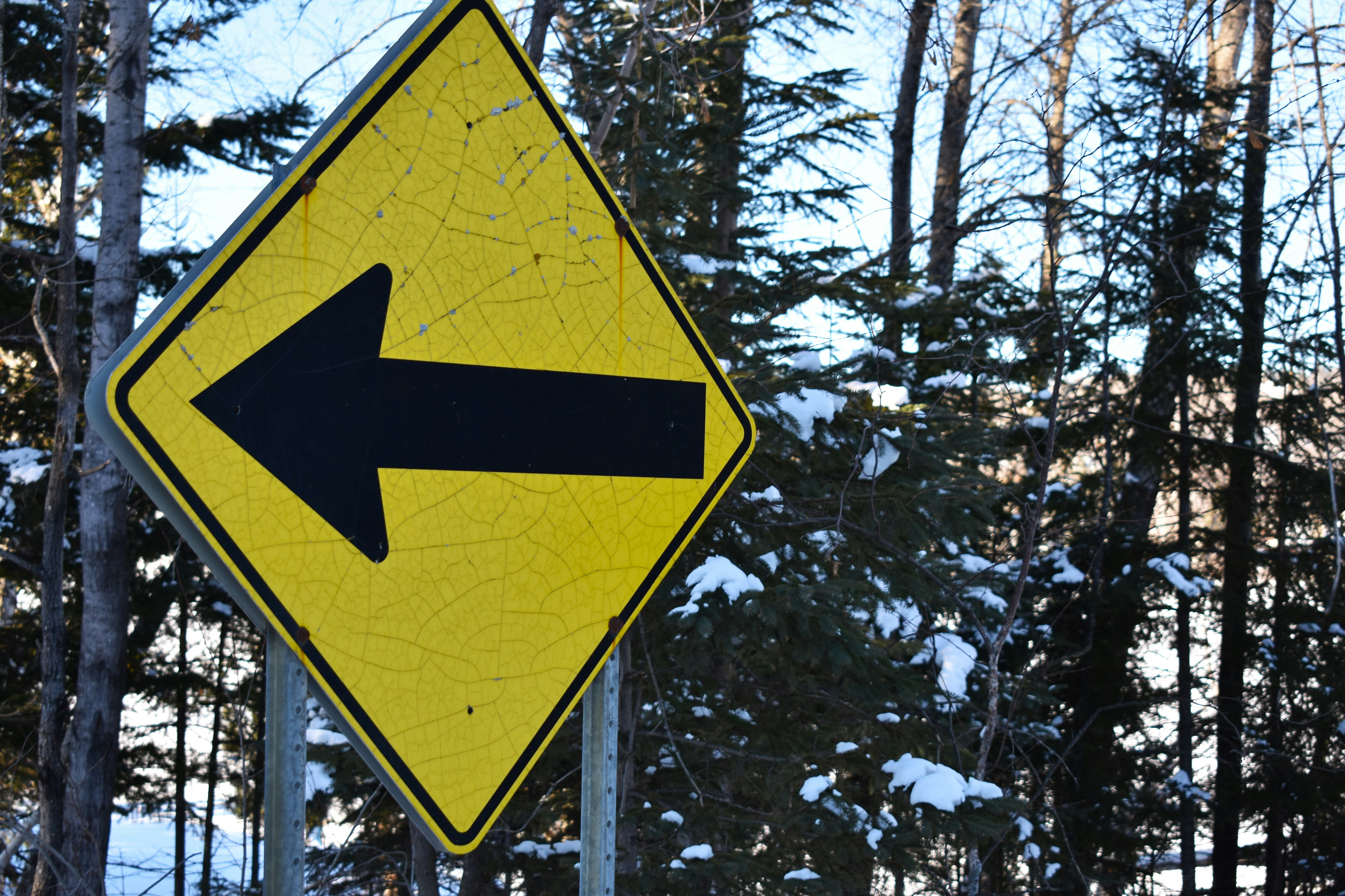 Yellow diamond sign with black arrow pointing left