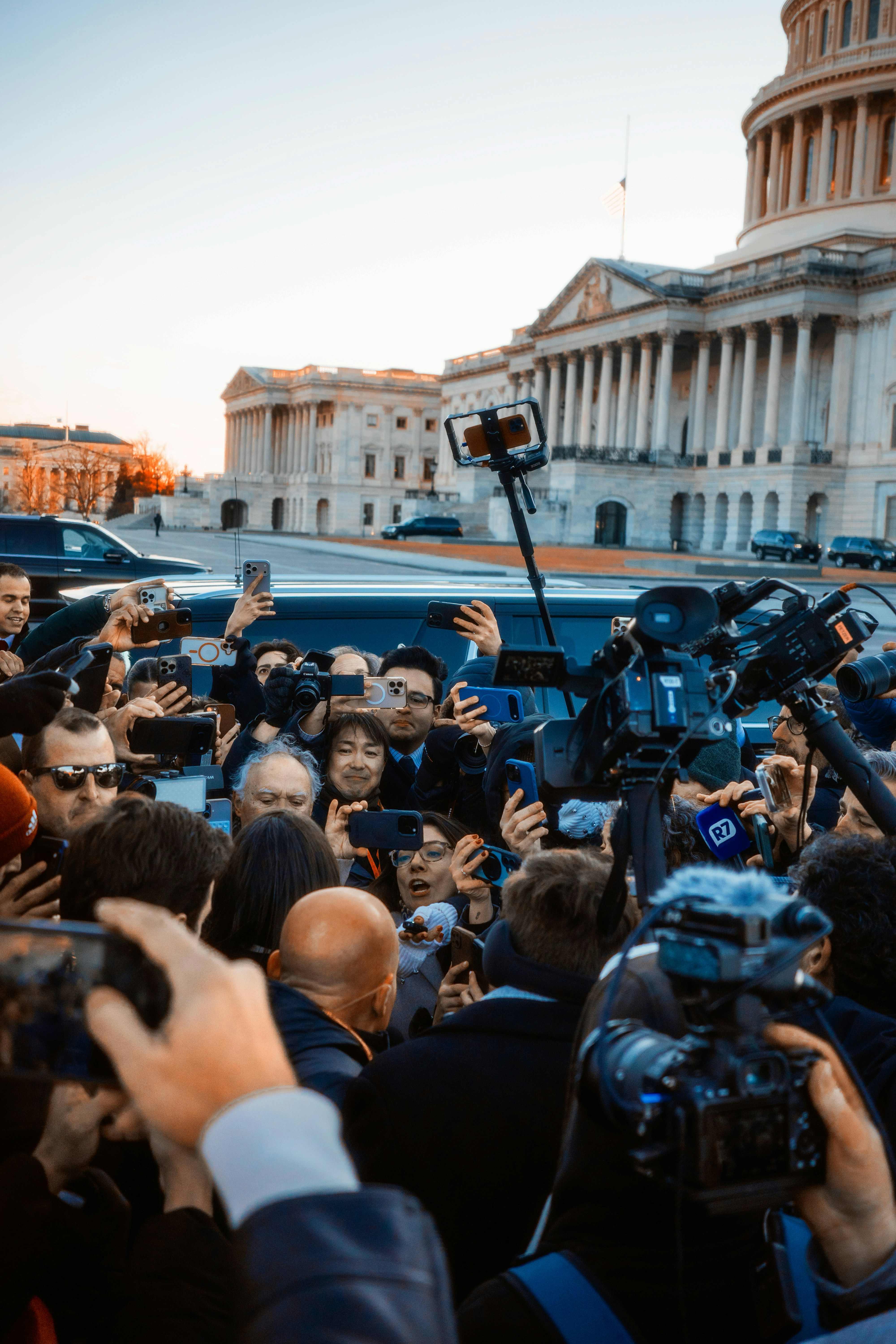 Crowd of reporters and onlookers with cameras and phones