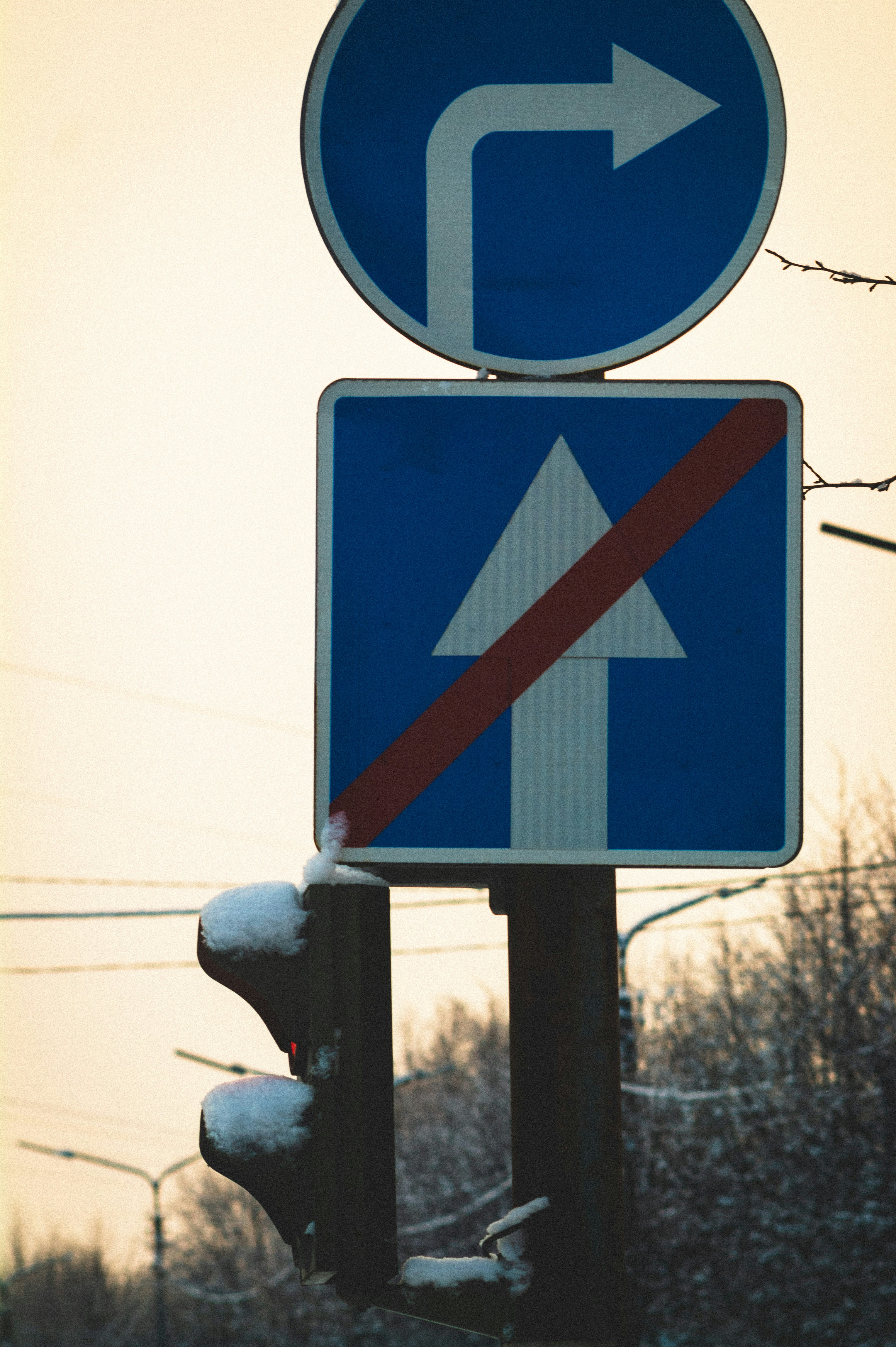 Traffic signs with snow on traffic light