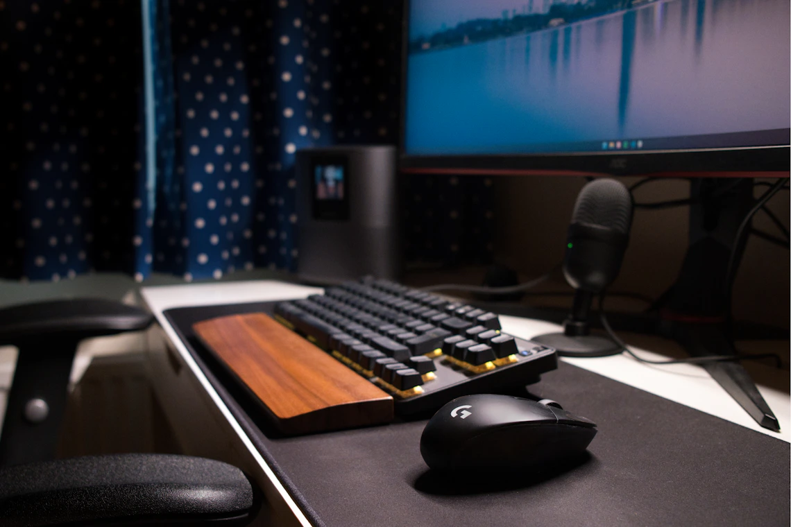Real computer gaming setup with monitor, keyboard, mouse, and microphone