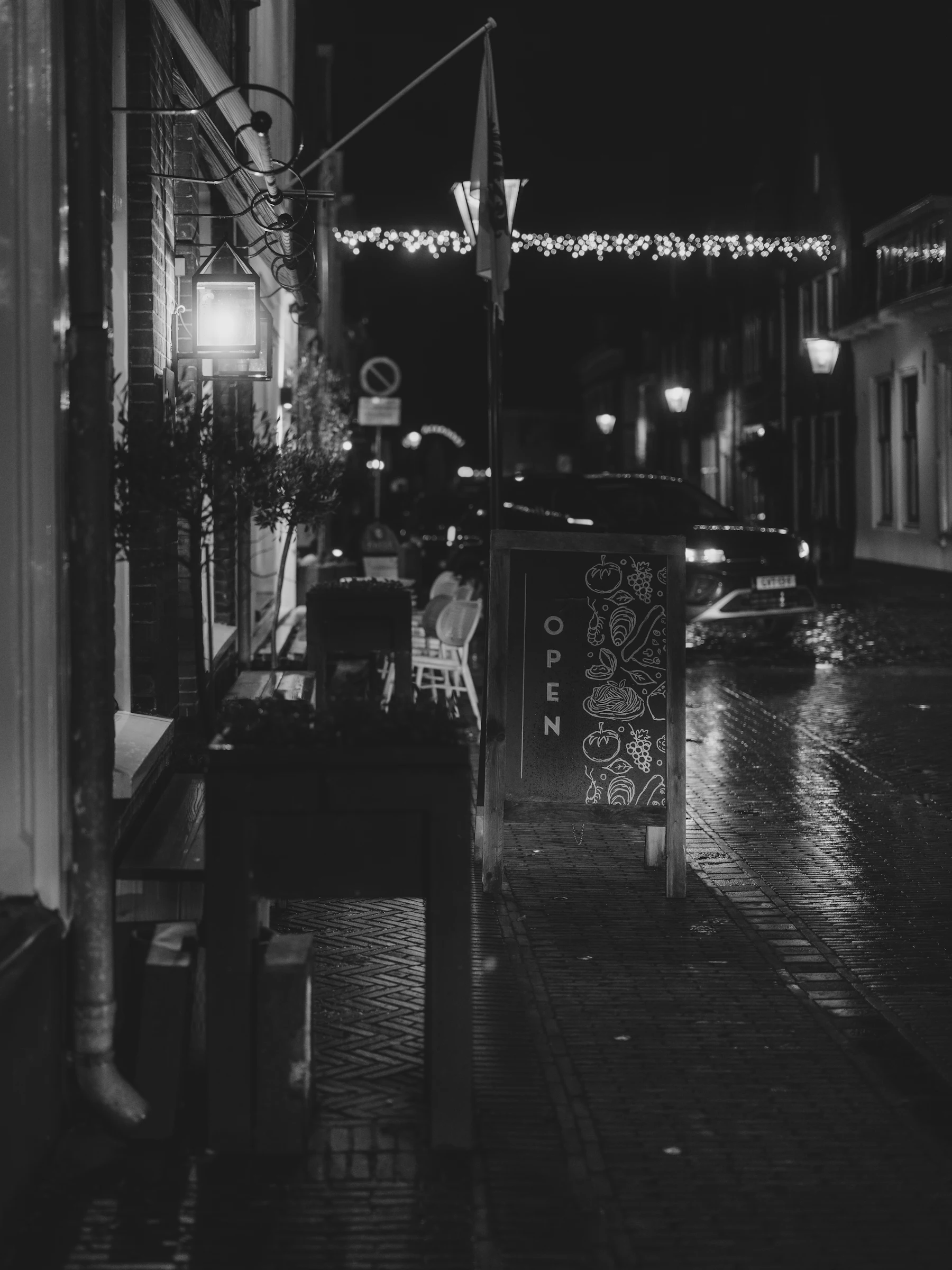 Wet street outside a cafe at night