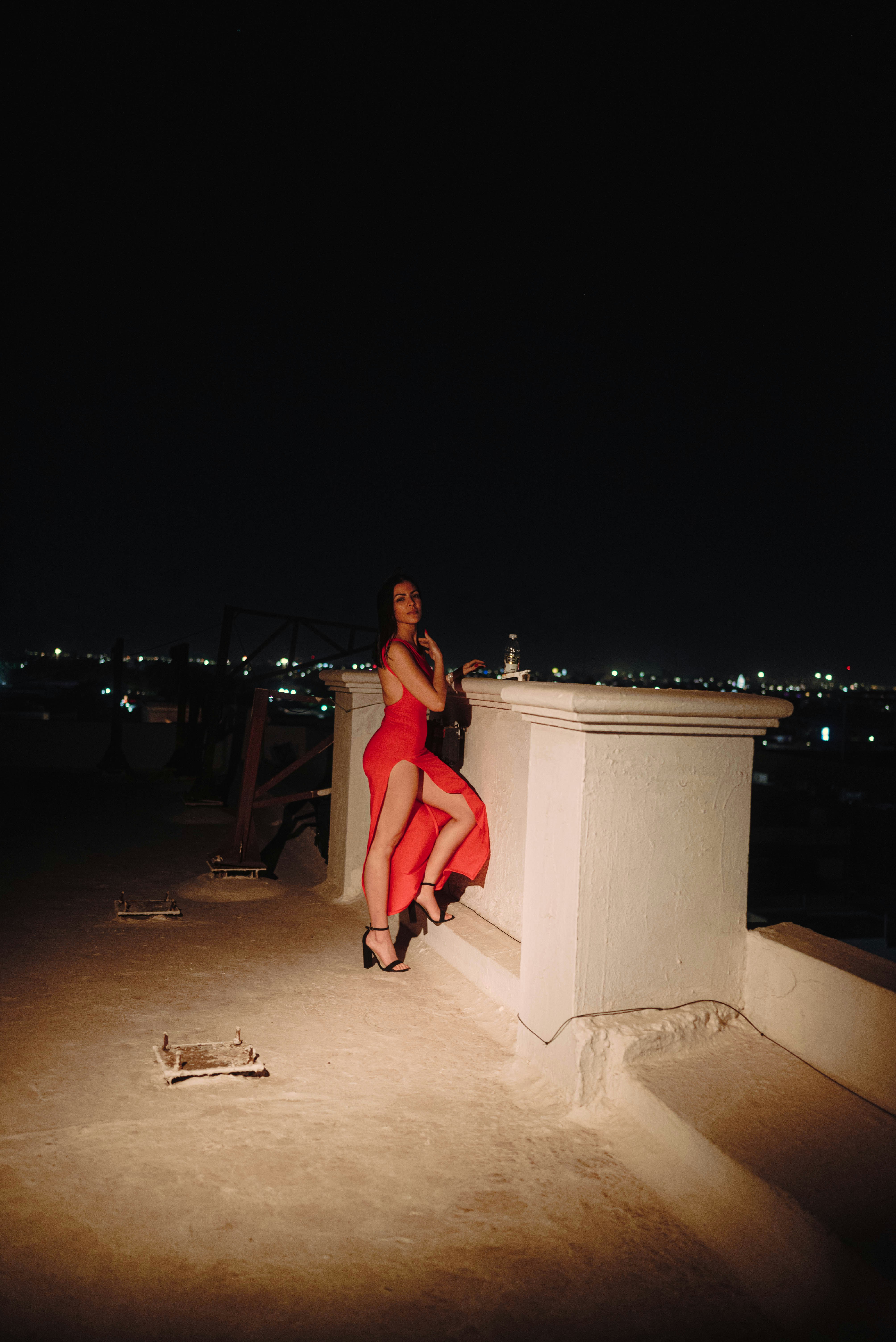 Woman in red dress on rooftop at night