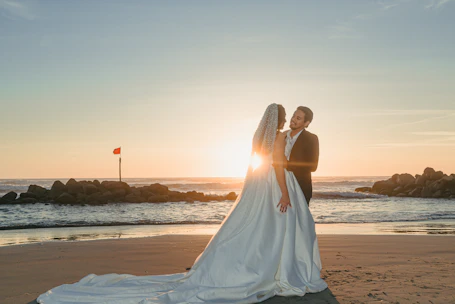 Bride and groom embracing on a beach at sunset