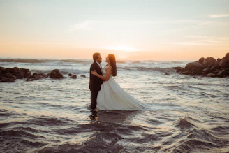 Couple embracing in the ocean at sunset