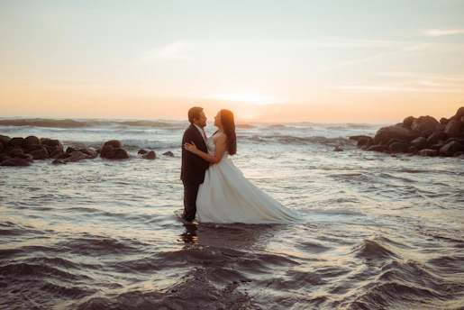 Couple embracing in the ocean at sunset