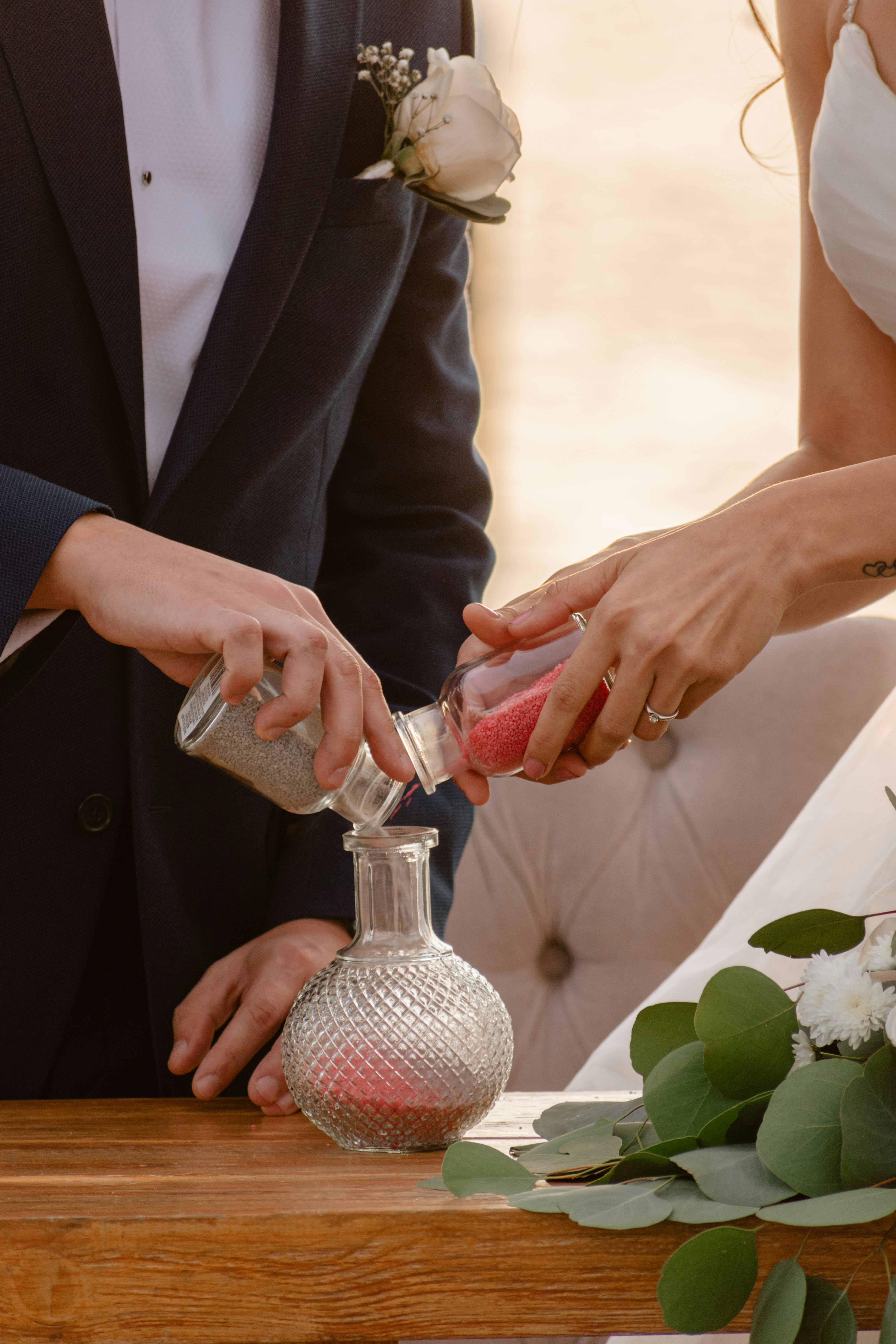 Couple performs sand ceremony during wedding