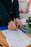Couple signing marriage license during wedding ceremony.