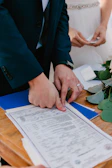 Couple signing marriage license during wedding ceremony.