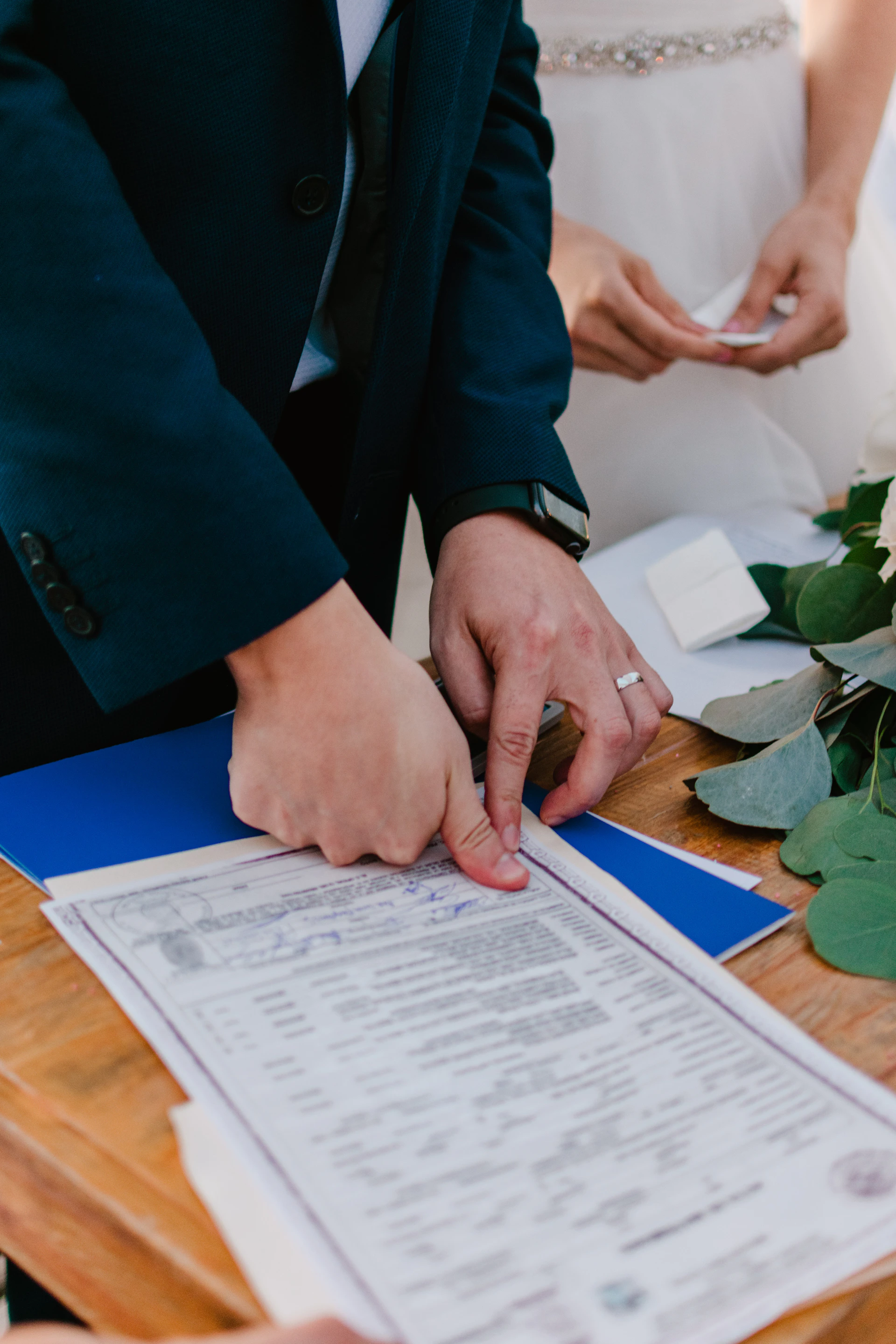 Couple signing marriage license during wedding ceremony.