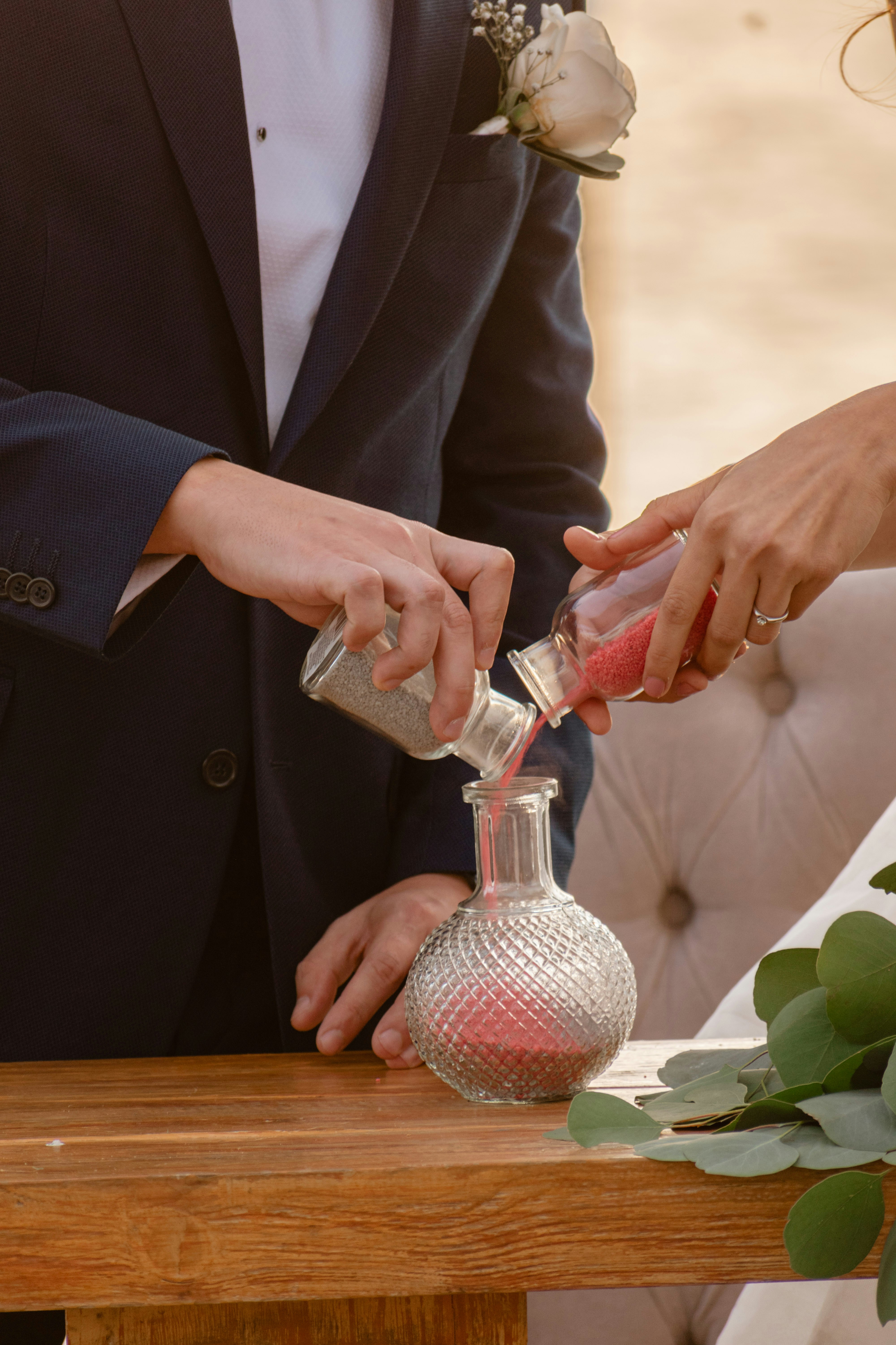 Couple performing a sand ceremony at a wedding.