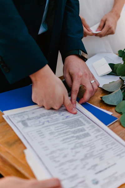 Couple signing marriage certificate with officiant present