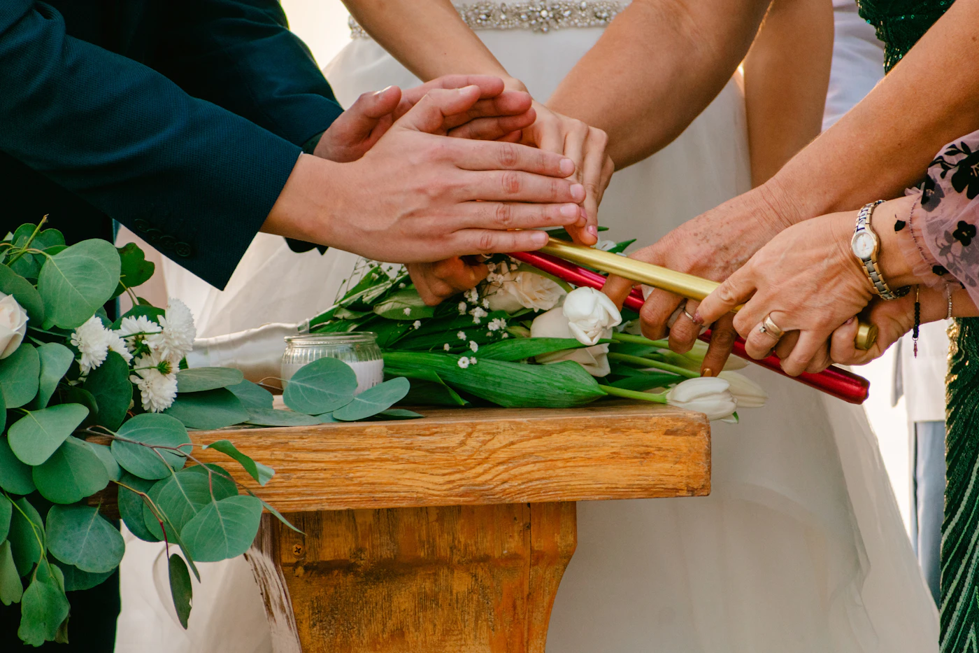 Unique unity ceremony ideas beyond sand and candles — A couple’s hands bound with ribbon during a handfasting unity ceremony.