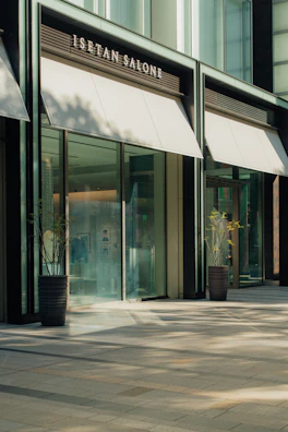 Modern building entrance with awnings and plants.