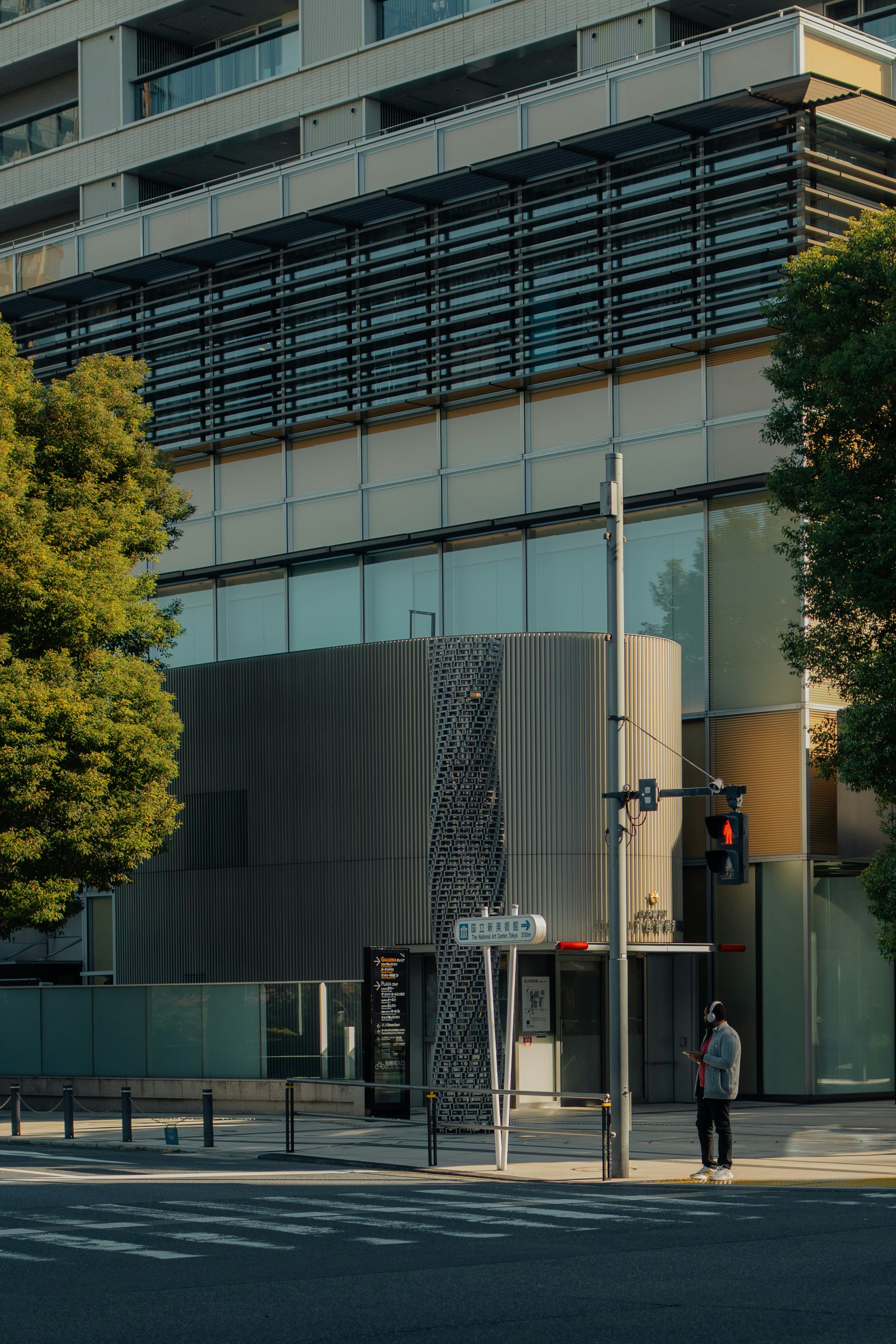 Man stands on sidewalk by modern building