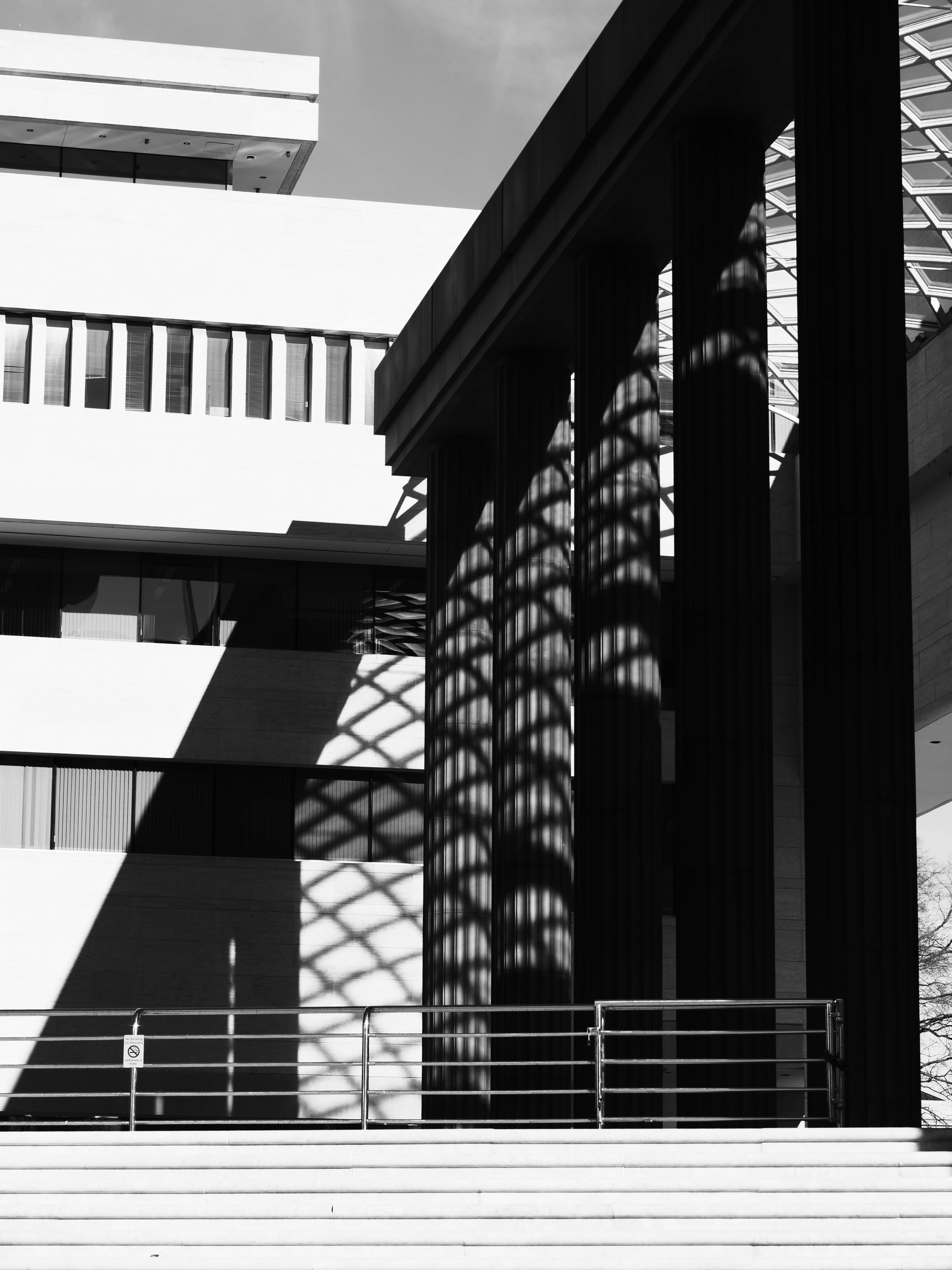 Geometric shadows cast on dark columns and white wall
