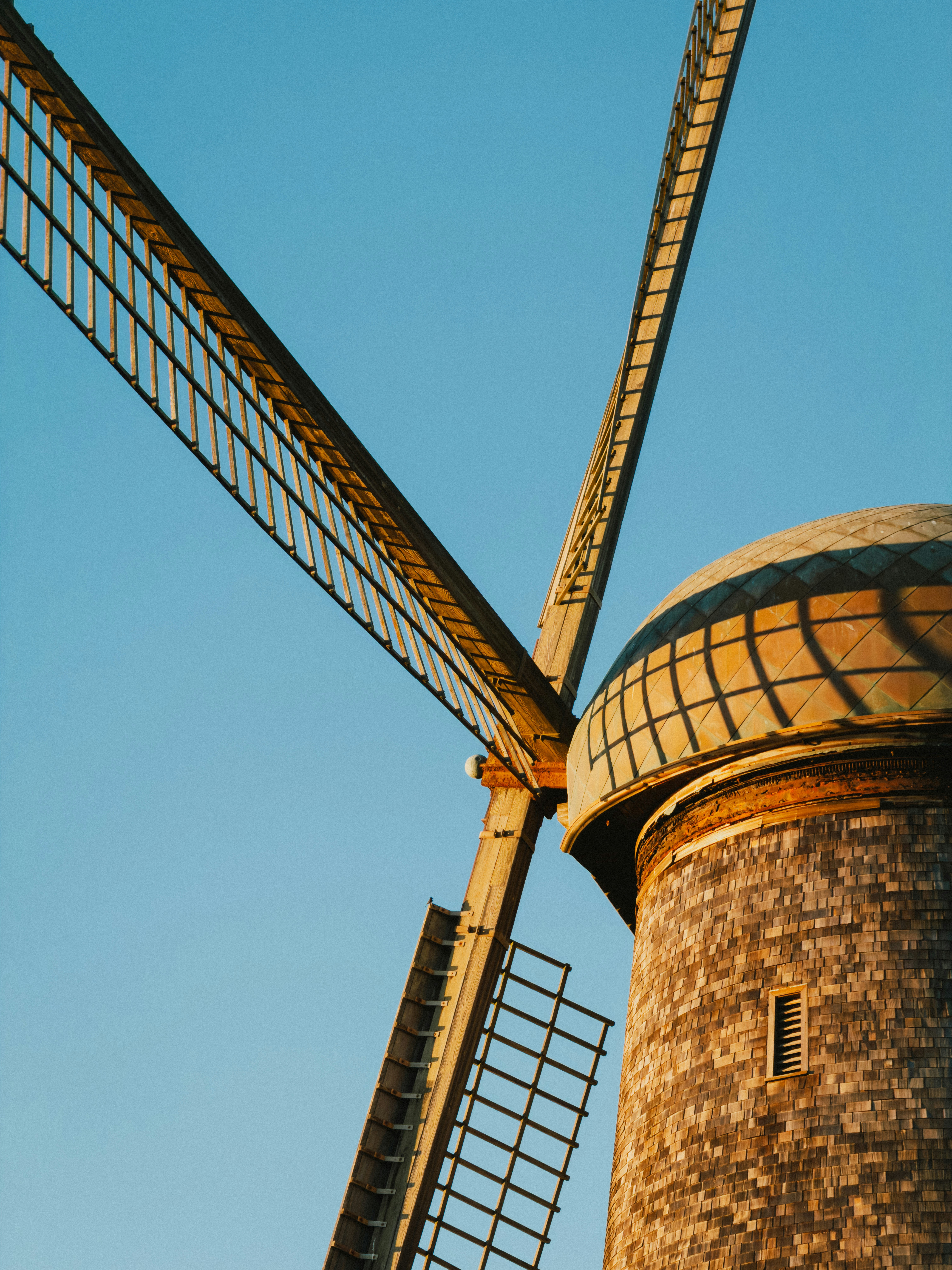 Close-up of a historic windmill against a clear blue sky