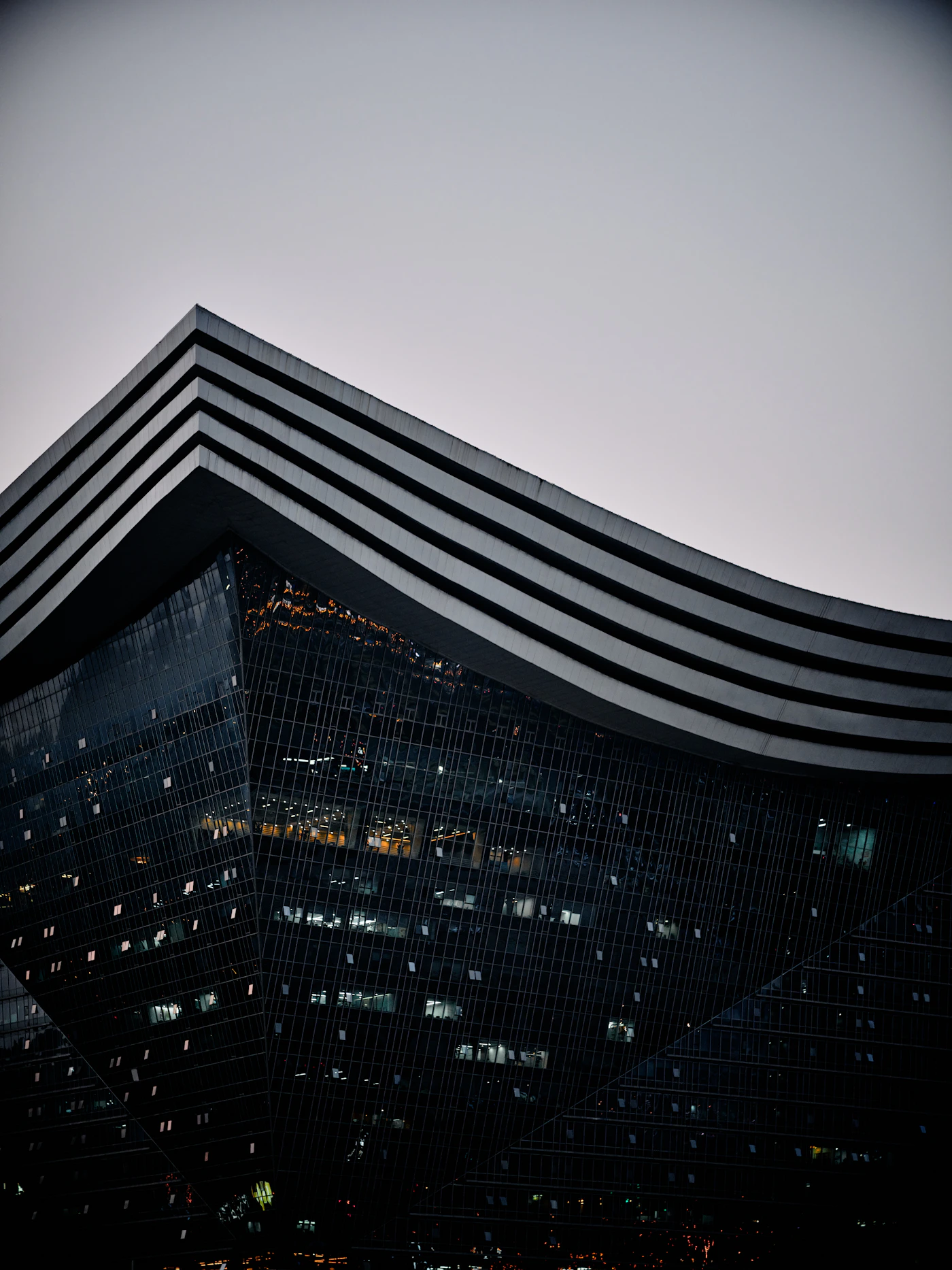 Cinematic view of a modern glass skyscraper at dusk