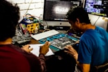 Two men working on a computer motherboard