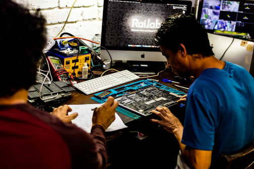 Two men working on a computer motherboard