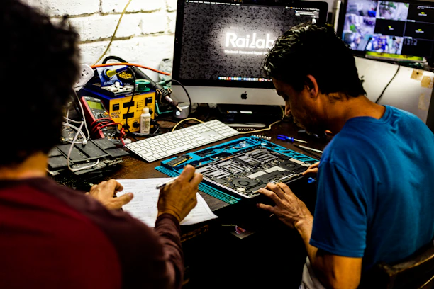 Two men working on a computer motherboard