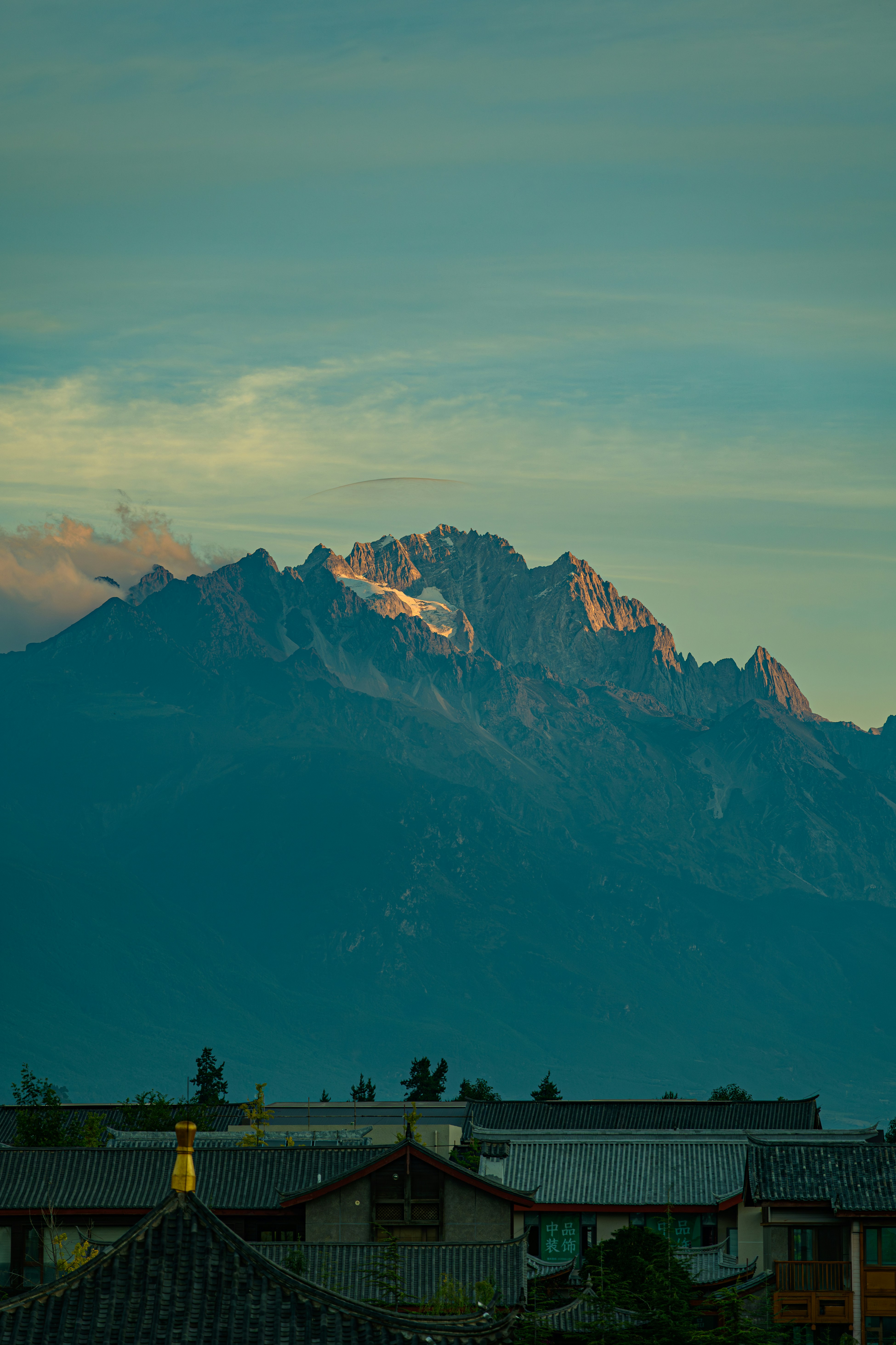 Snow-capped mountain peak illuminated by golden sunrise light