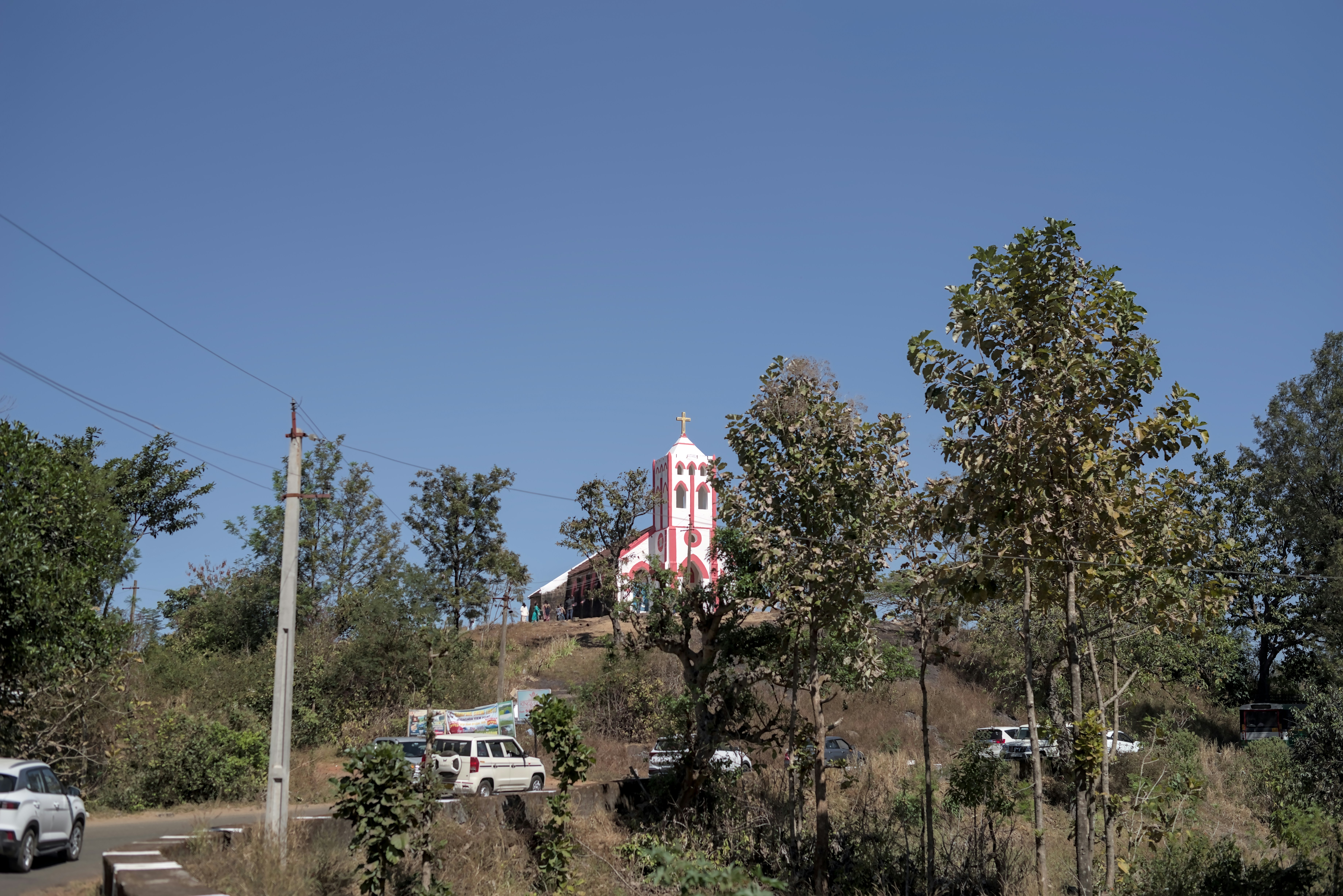 A pink and white church on a hill.