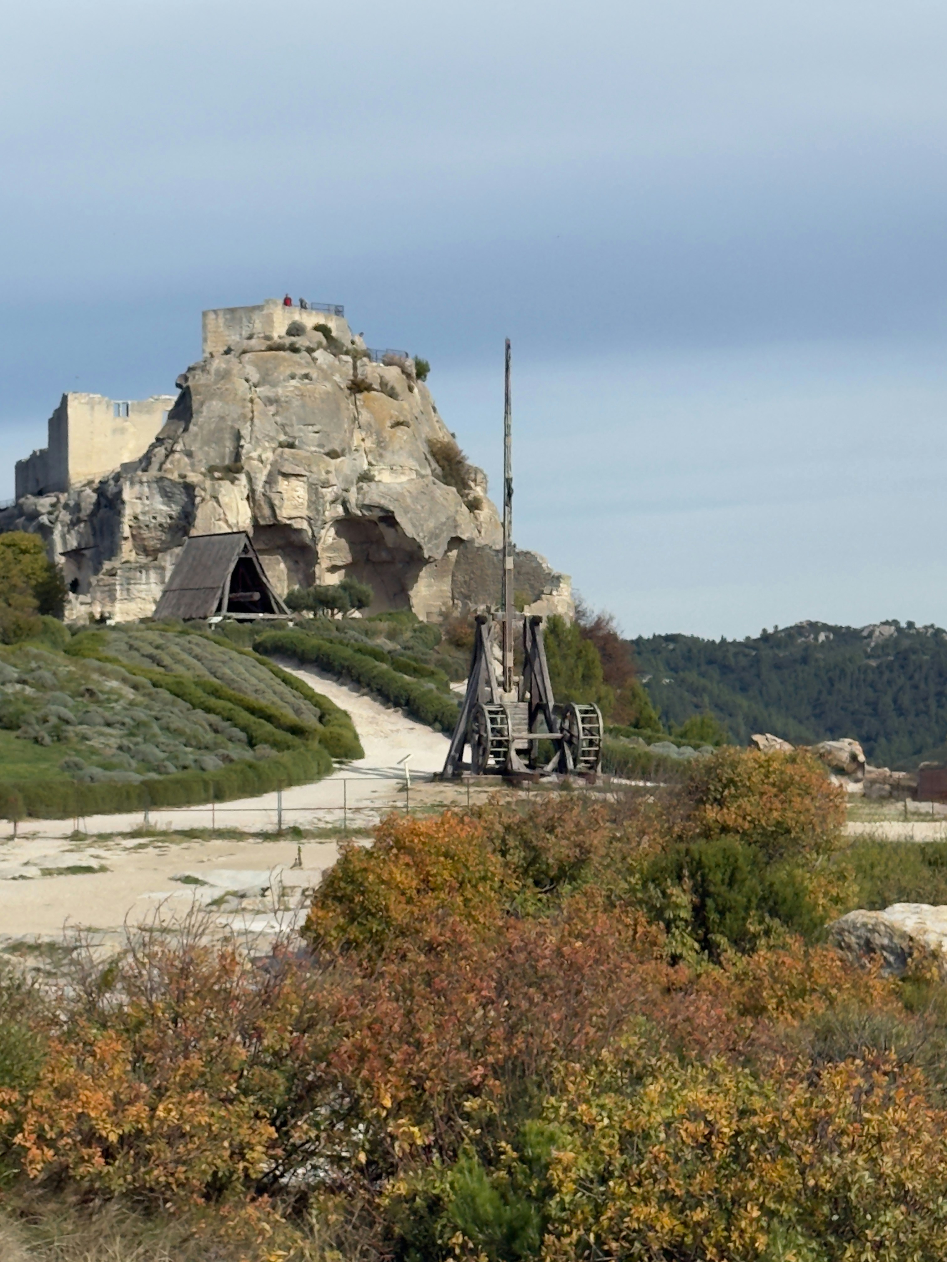 Ancient stone fortress on a rocky hilltop with trebuchet.