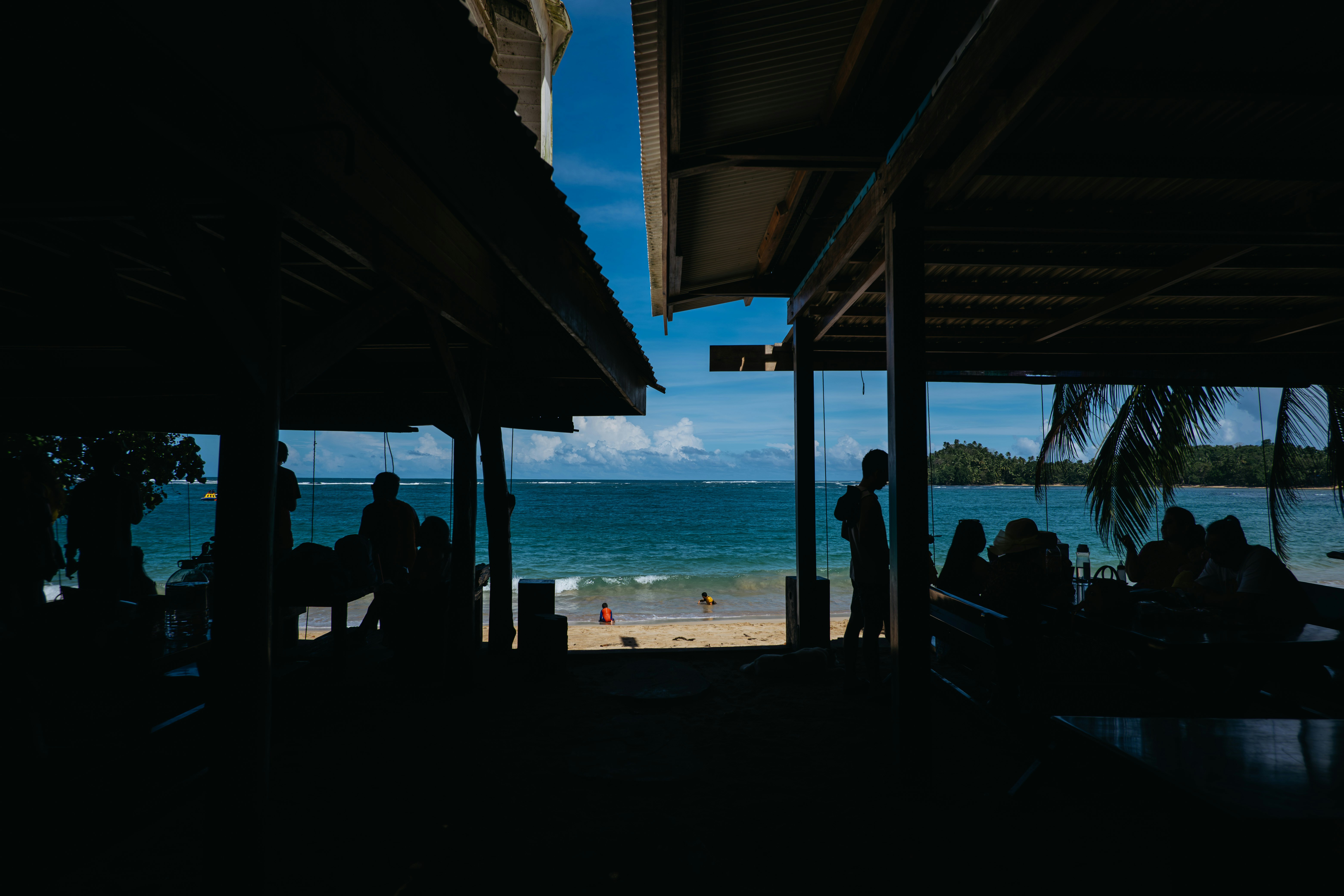 Persone che si rilassano in un caffè sulla spiaggia con vista sull'oceano.