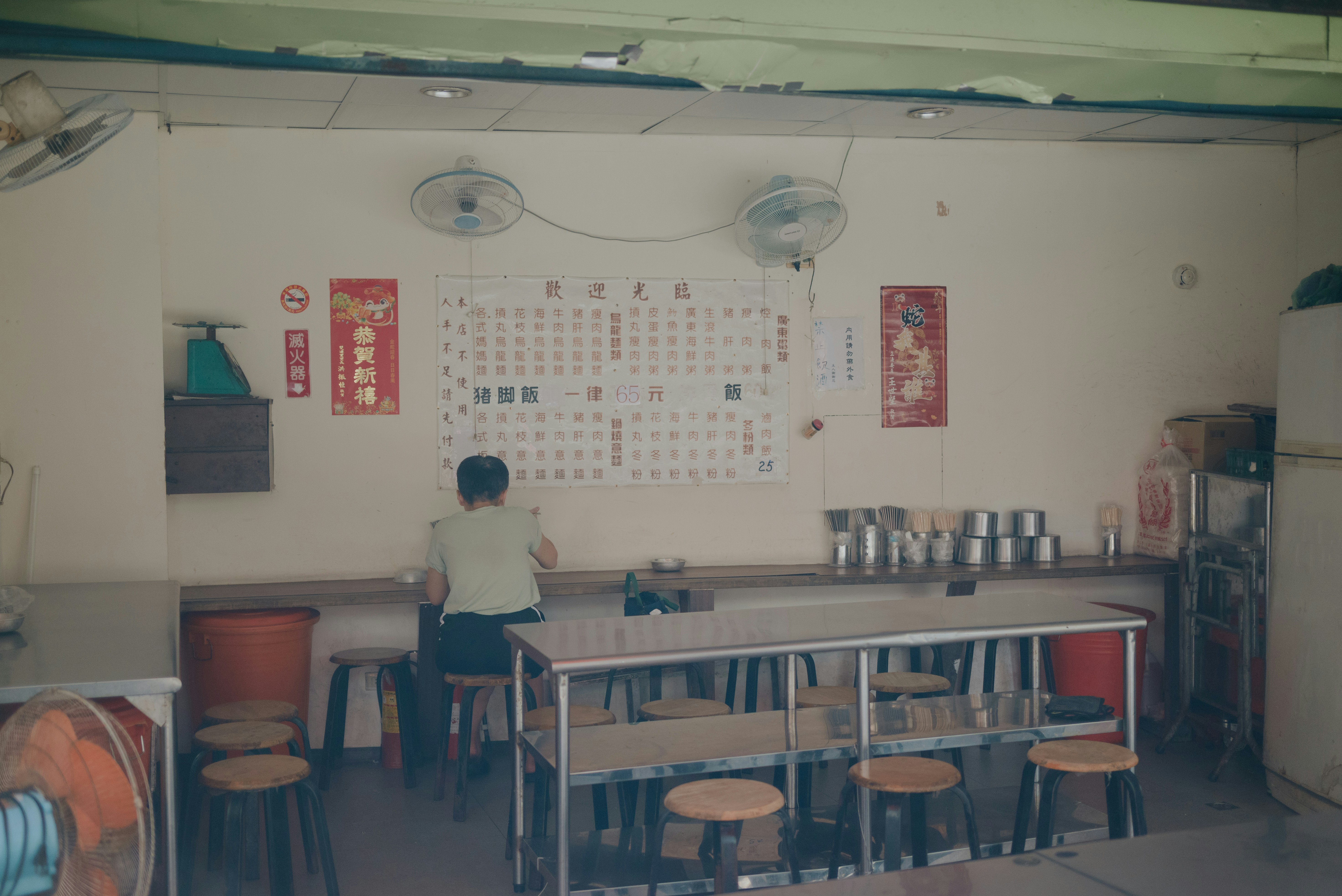 Person working at a table in a small restaurant or cafe