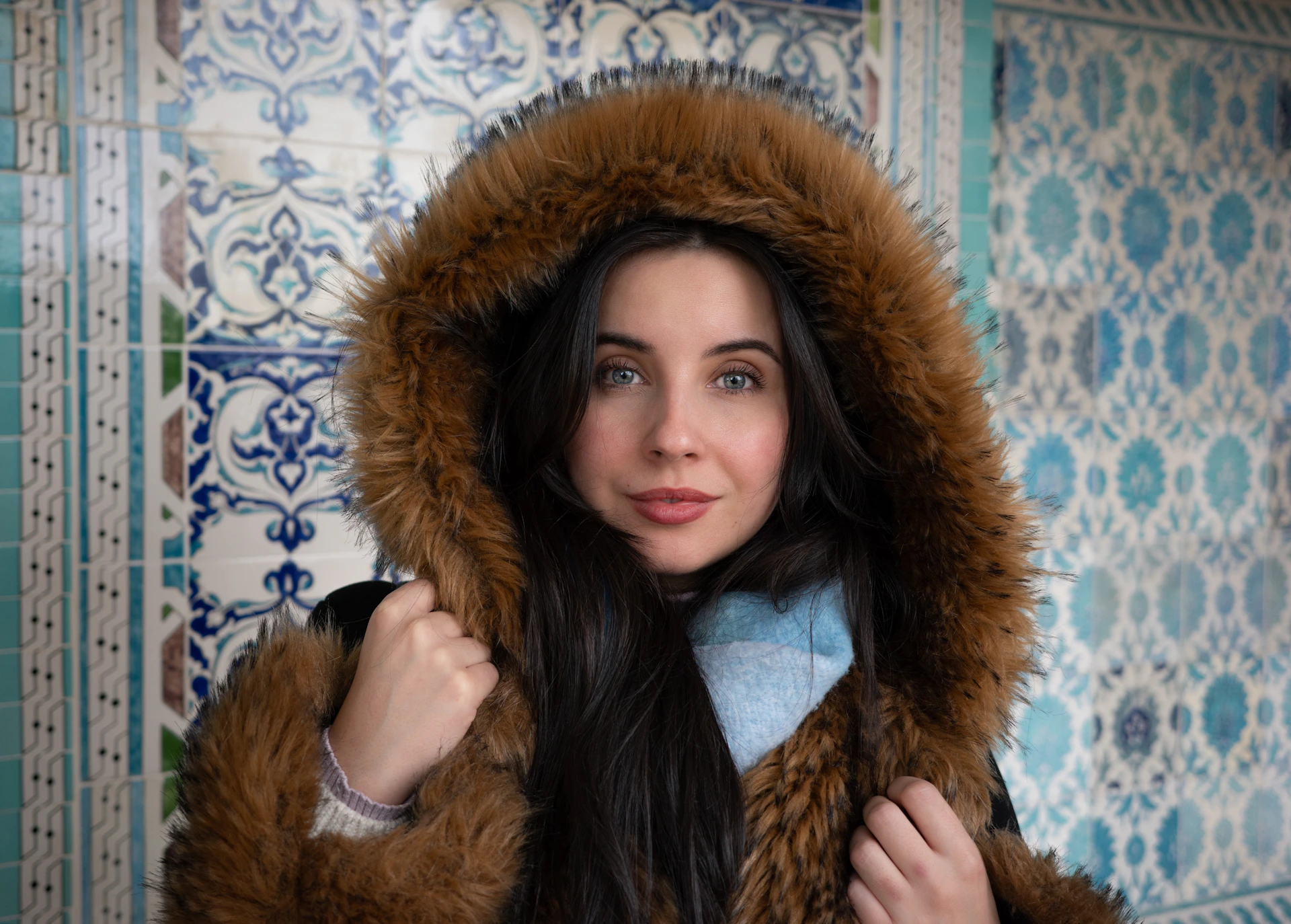 Woman in fur-lined hooded coat with blue scarf