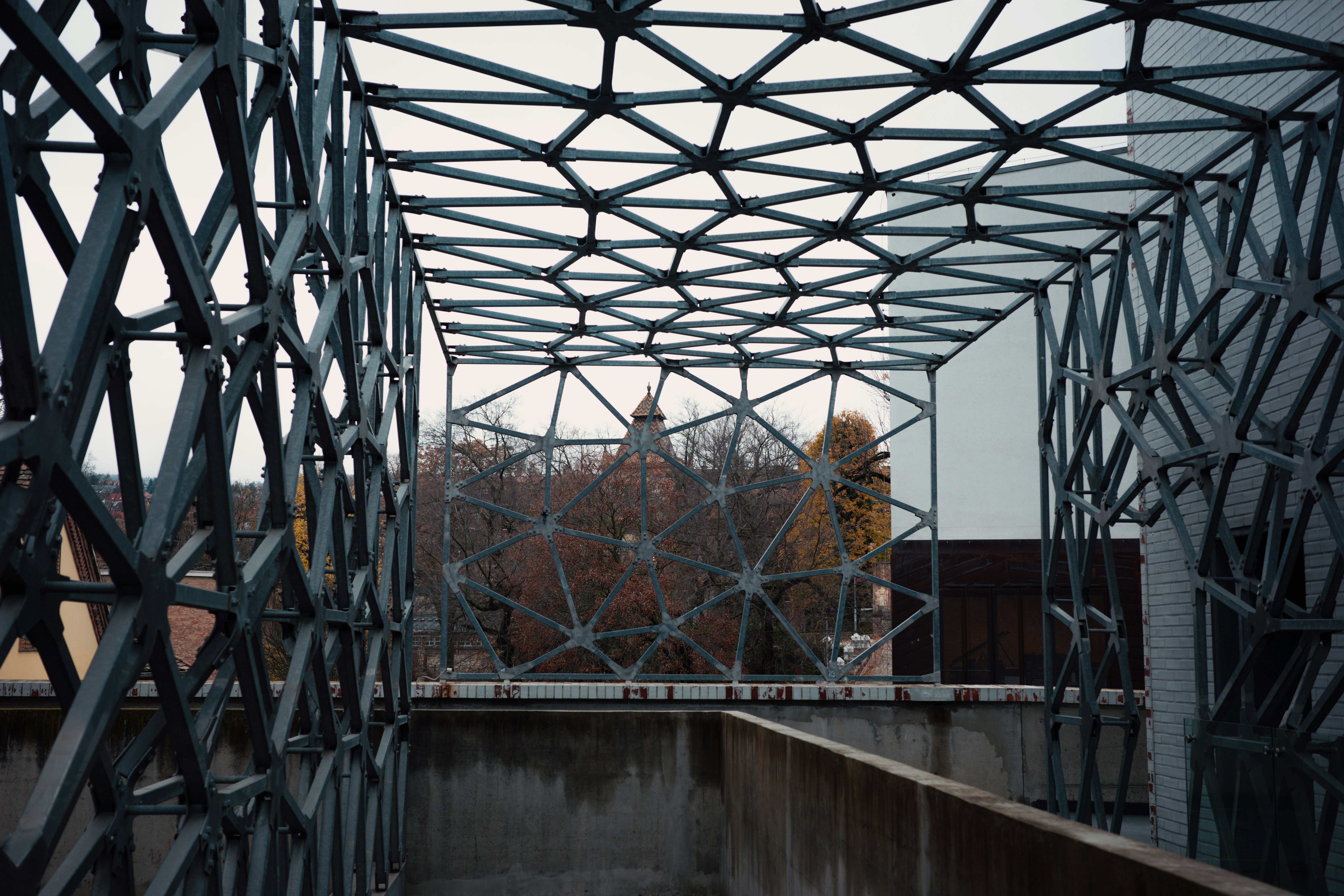 Modern geometric structure with a building in background