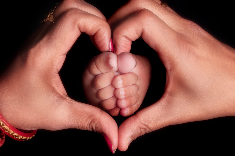 Parents hands form heart around baby's feet